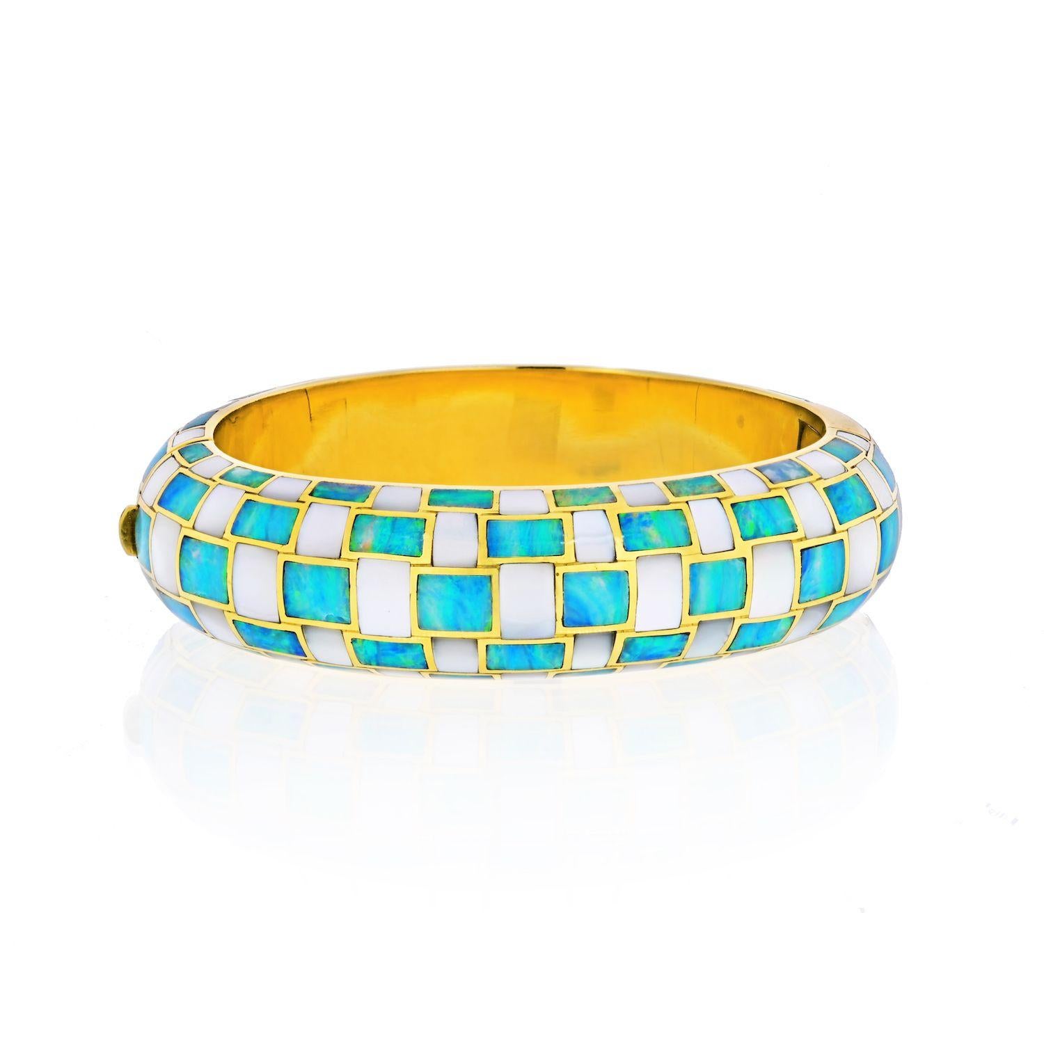 A truly eye-catching bracelet. Maker's mark for Angela Cummings.
The 18k gold hinged bangle features inlaid mother-of-pearl and opal, marked for Angela Cummings and Tiffany & Co. Gross weight 55.50 grams.
Dimensions: 6-1/2 inches x 11/16 inch.
From