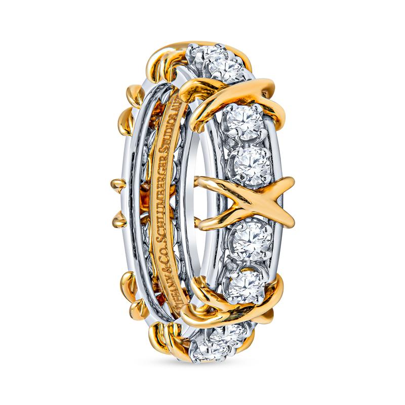 This iconic ring from Tiffany & Co. by Jean Schlumberger features approximately 1.14 carat total weight in round brilliant diamonds set in platinum that alternate with dazzling 18 karat yellow gold X's. It is a size 7. Stamped Tiffany 
& Co.