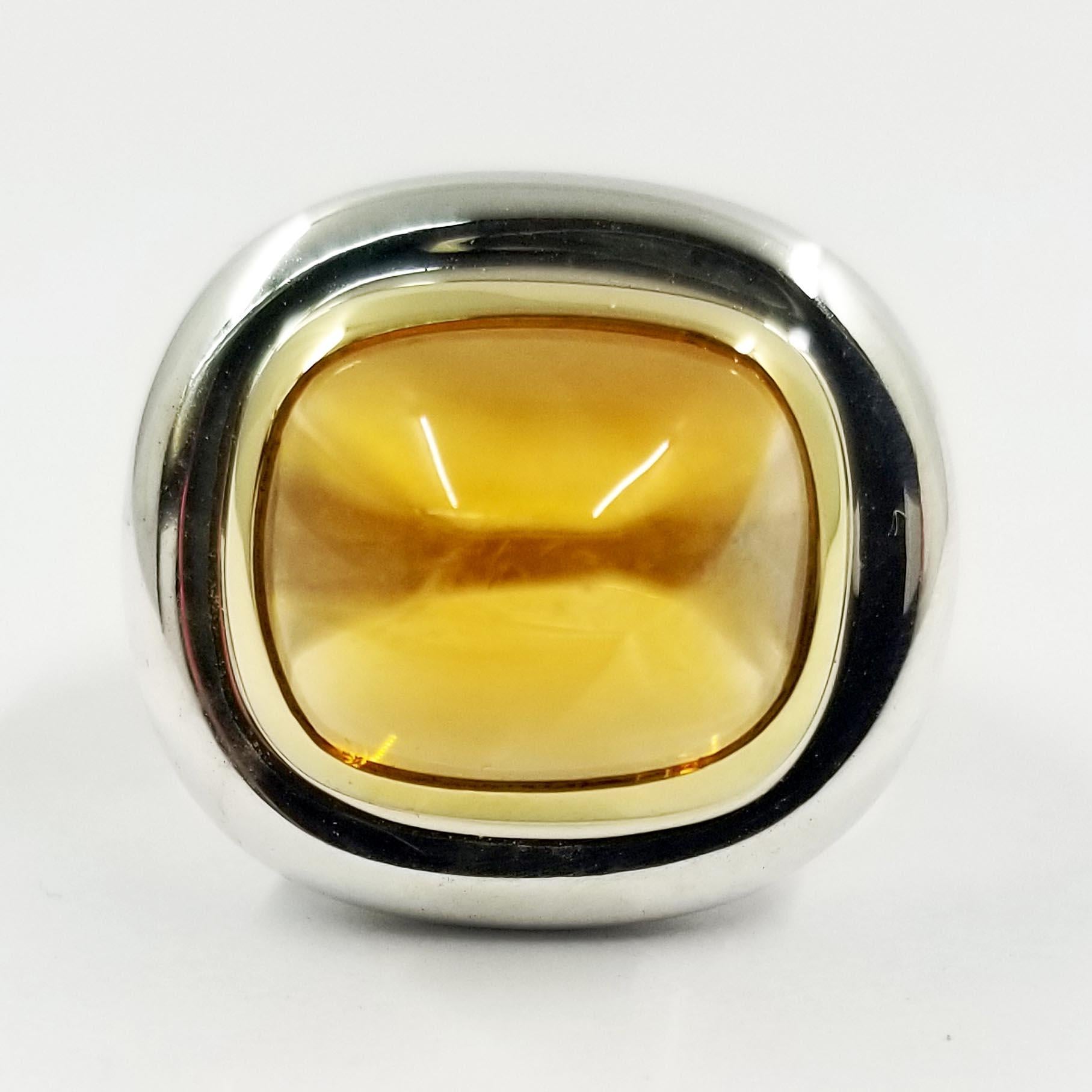 This modern ring is designed by Paloma Picasso for Tiffany & Co. It is crafted in both sterling silver and 18 karat yellow gold. The ring features a bezel set cabochon cut citrine quartz center stone. Current finger size 5.5; purchase includes free