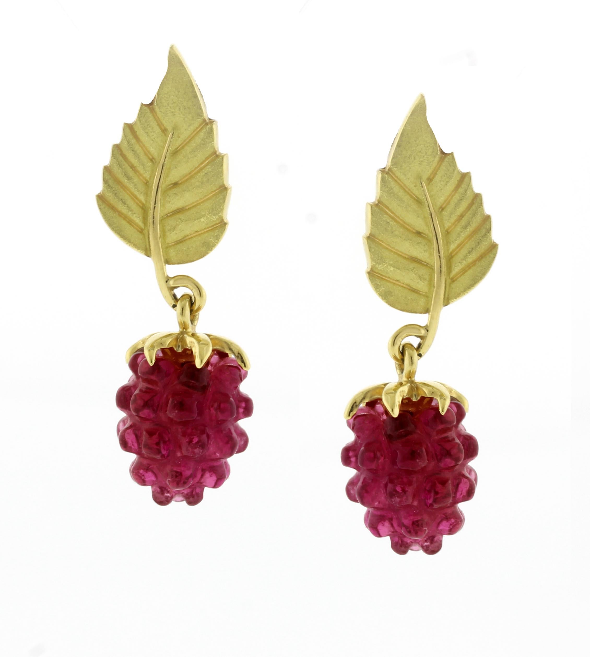 From Tiffany & Co., a pair of carved garnet raspberry and single 18 karat leaf earrings. The top leaf measure 13.7mm by 8.2mm, the drop measures 14mm long. Tiffany pouch and earring backs 