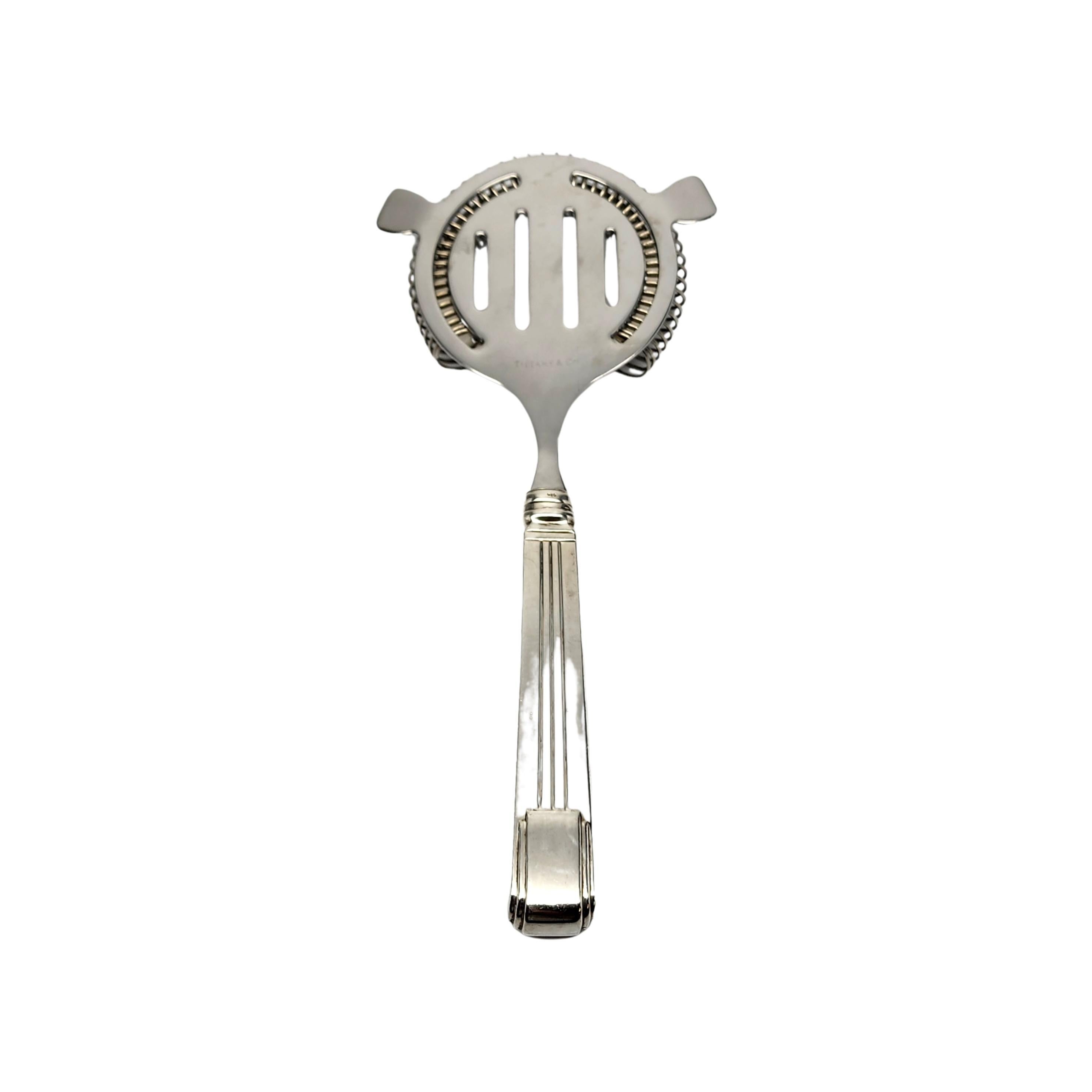 Sterling silver handle cocktail strainer by Tiffany & Co's Century pattern.

No monogram

The Century pattern was designed by Arthur LeRoy Barney in 1937 as part of Tiffany's 100th anniversary celebration. Tiffany's first modern design pattern, it