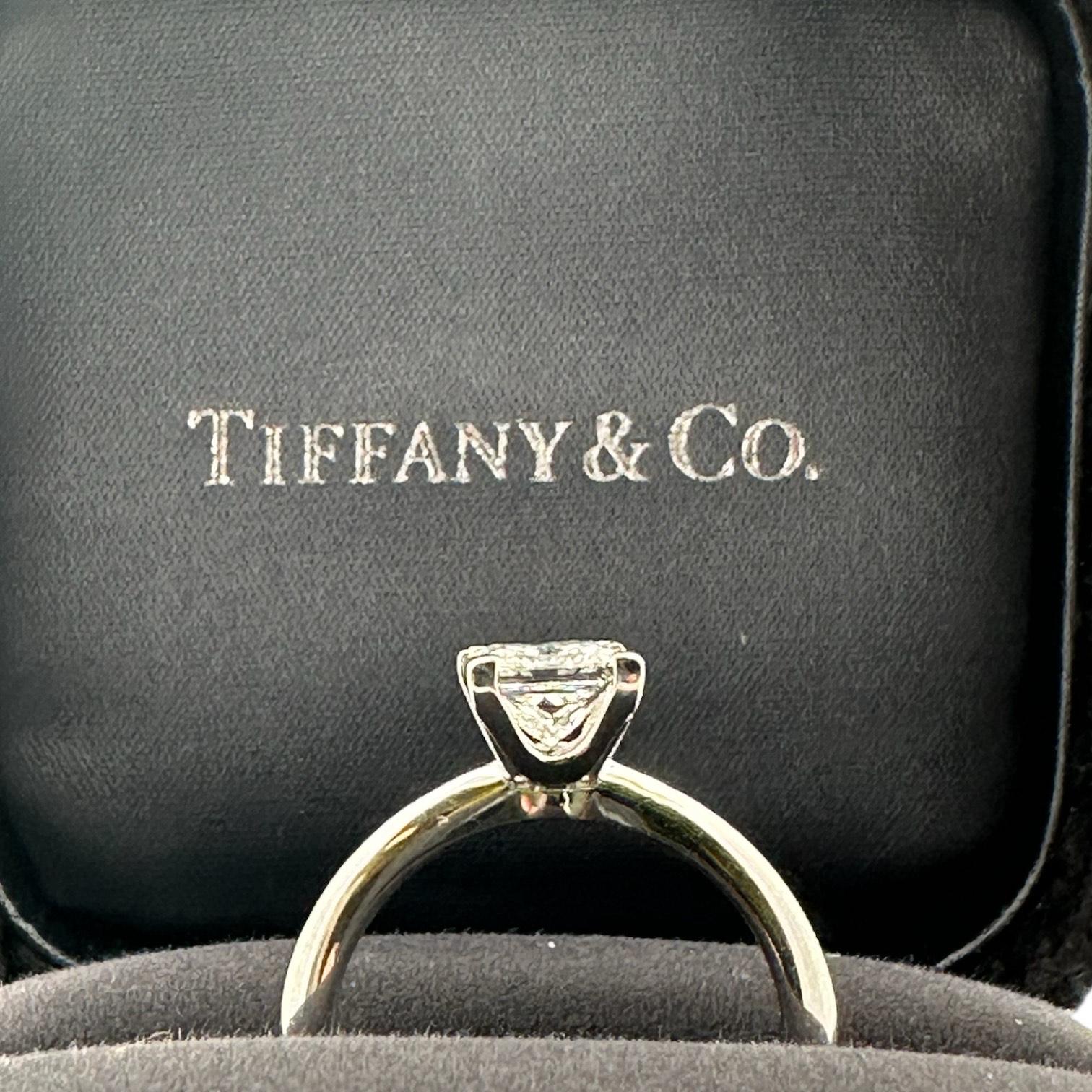 Tiffany & Co platinum four prong setting featuring an exquisite square modified brilliant cut diamond weighing .93ct with a color grade of F and VVS2 clarity. The inside of the ring is marked 