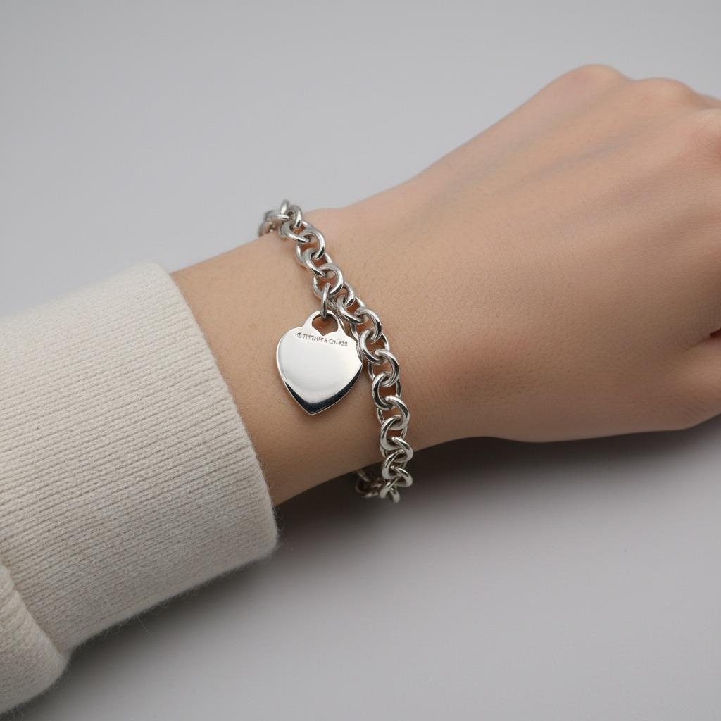 Adopta la elegancia atemporal con este clásico de Tiffany & Co. Pulsera de cadena de plata de ley con el emblemático colgante de corazón, un símbolo de amor y lujo que ha cautivado a los amantes de la joyería durante generaciones.

Esta