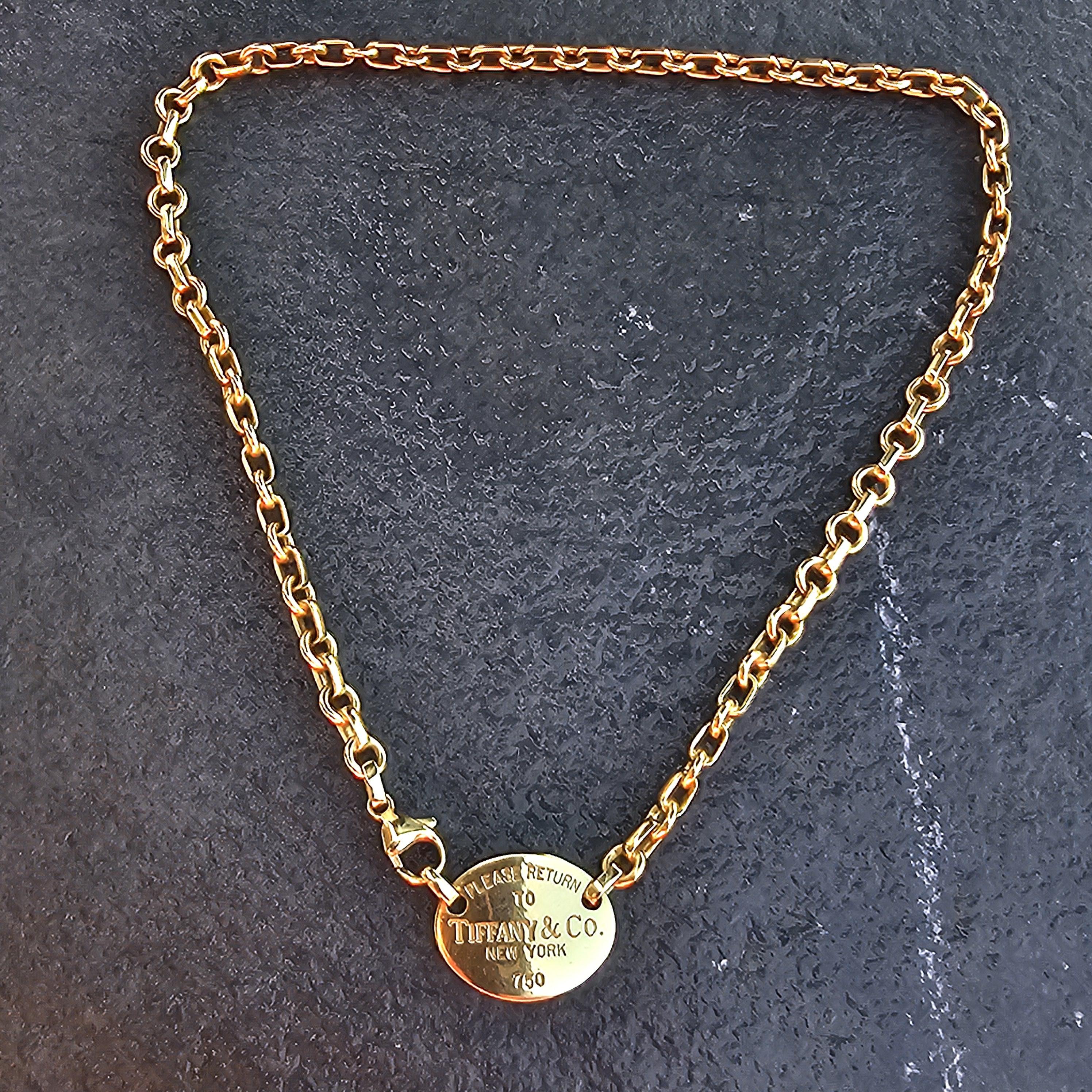 This Tiffany & Co. choker necklace is a stunning piece. Crafted from 18k yellow gold, it features a classic chain design with an engraved oval tag. The necklace is a perfect accessory for any occasion, adding a touch of elegance. Known for