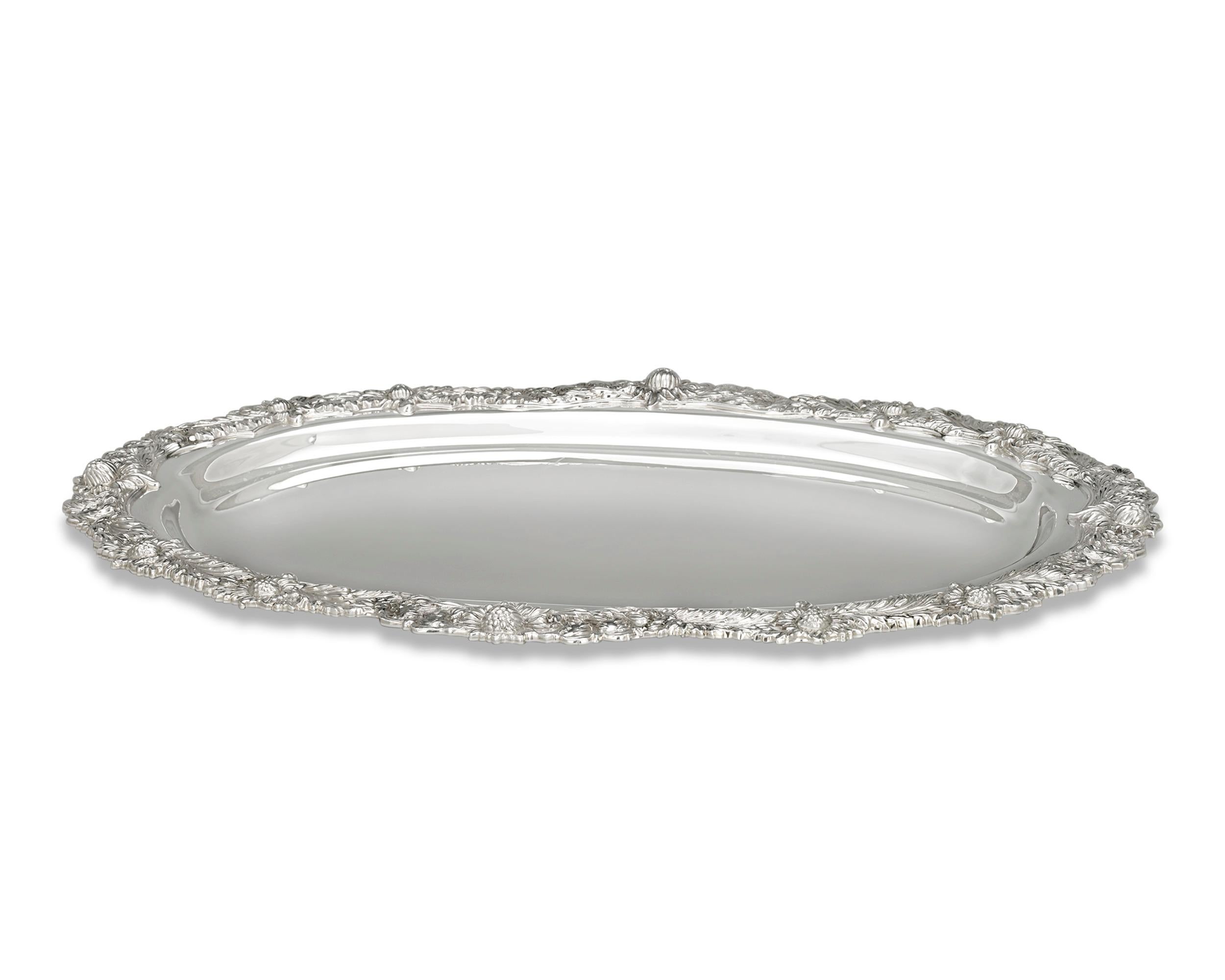This sterling silver tray was crafted by the incomparable Tiffany & Co. in the widely recognized Chrysanthemum pattern. The motif's namesake flowers are expertly chased and applied around the elegantly scalloped rim. Expertly crafted, the highly