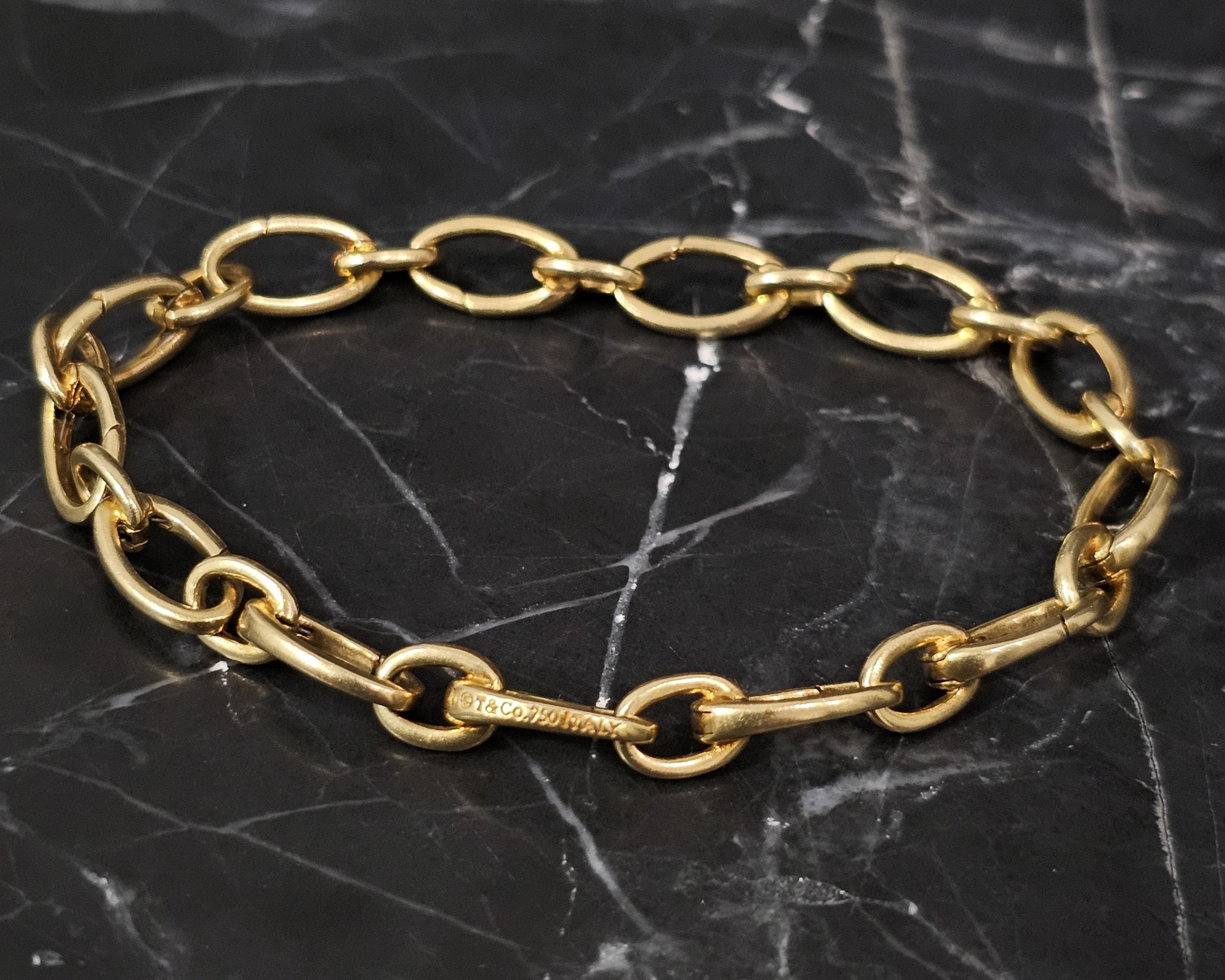 This elegant Tiffany & Co. bracelet features a classic link design, crafted in luxurious 18k yellow gold. The chain bracelet measures 7.5 inches in length and 0.25 inches in width, offering a refined and timeless look. Weighing 15.8 grams, this