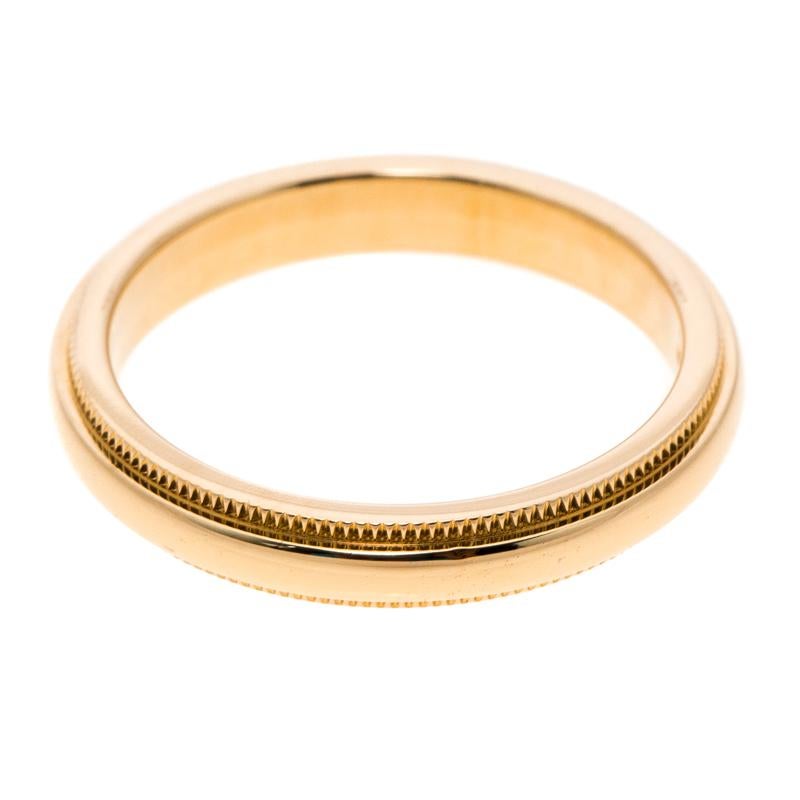To last momentously in honor of your precious bond of love, Tiffany & Co. brings you this minimally aesthetic Classic Milgrain wedding band ring. Crafted from 18k yellow gold in a sleek band, the piece flaunts elegantly textured edges which glorify