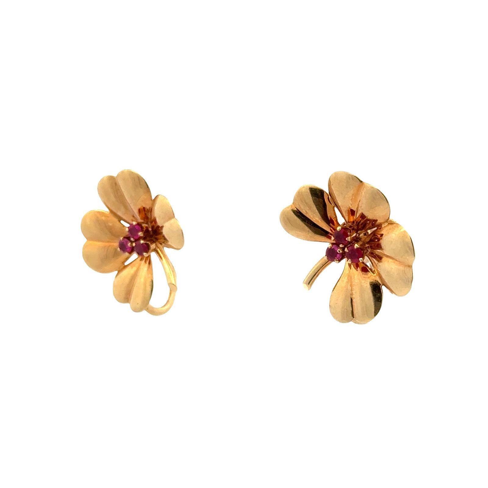 A timeless design from Tiffany & Co., these vintage earrings feature a charming four-leaf clover motif set with vibrant ruby accents. Crafted in rich 14 karat yellow gold, the earrings embody both elegance and good fortune, making them a classic