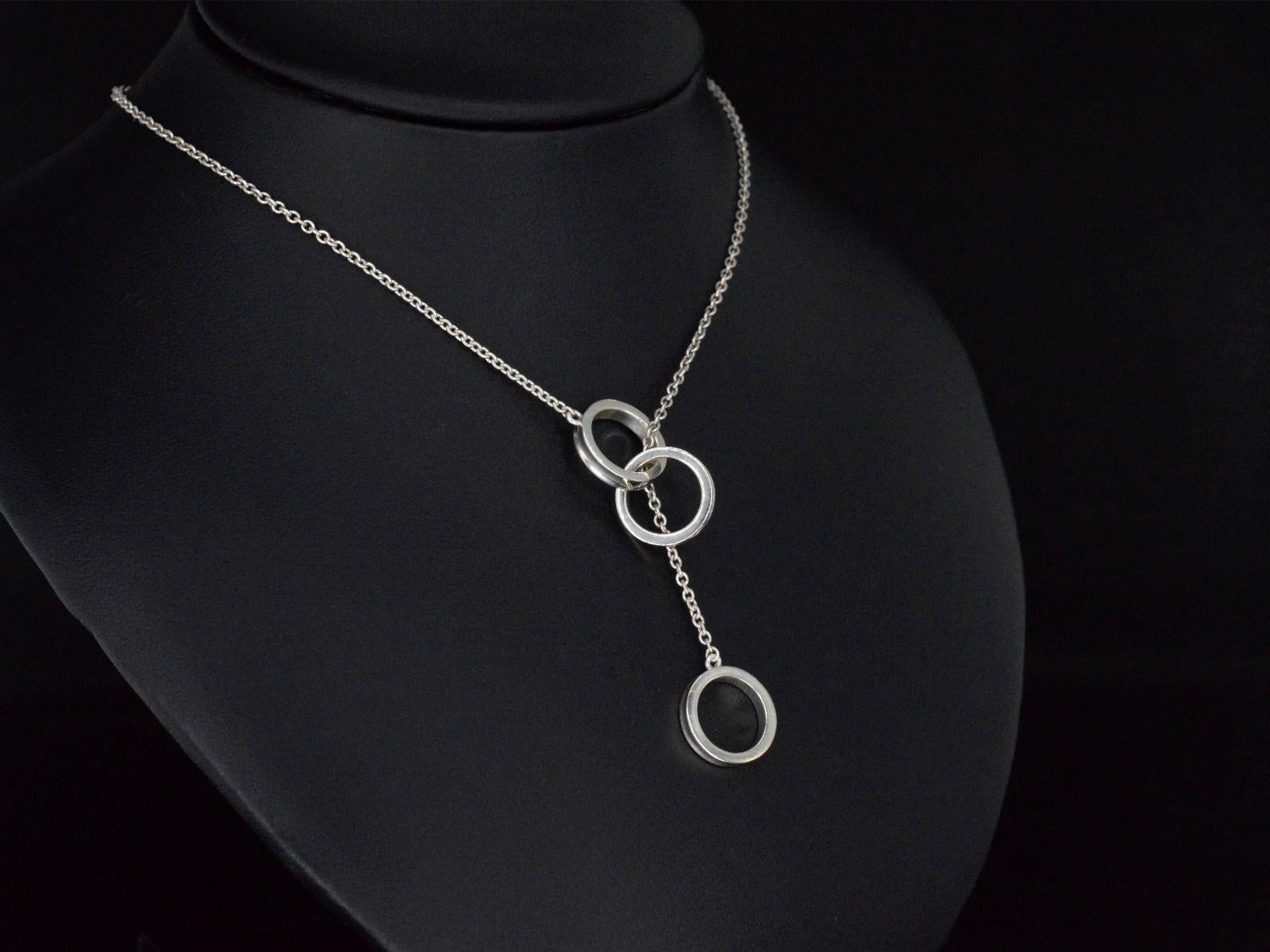 A stylish Tiffany & Co necklace featuring the elegant Interlocking Circles Pendant. This graceful necklace, weighing 5.0 grams and measuring 47.5 cm in length, is a testament to Tiffany & Co's timeless design. Crafted from sterling silver 925, it