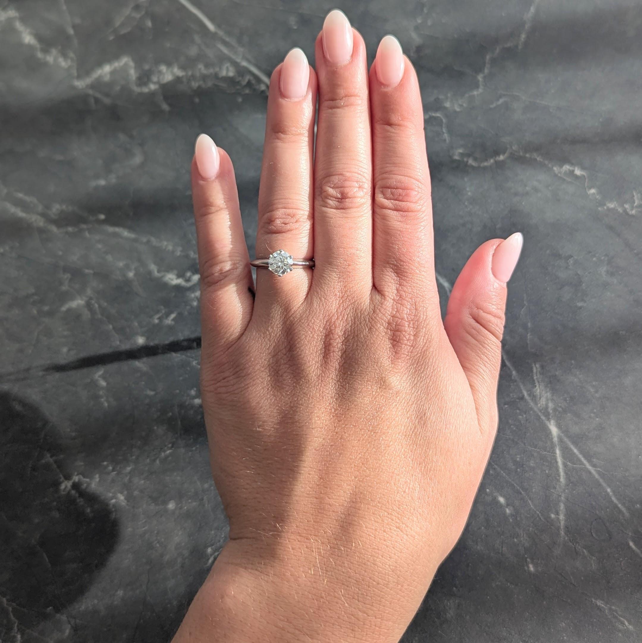 In der Mitte ein runder Diamant im Brillantschliff mit einem Gesamtgewicht von 1,13 Karat - Farbe G, Reinheit SI1
Fassung im klassischen Tiffany-Stil mit sechs Zacken
Akzentuiert durch einen hochglanzpolierten Messerschaft
Gestempelt für