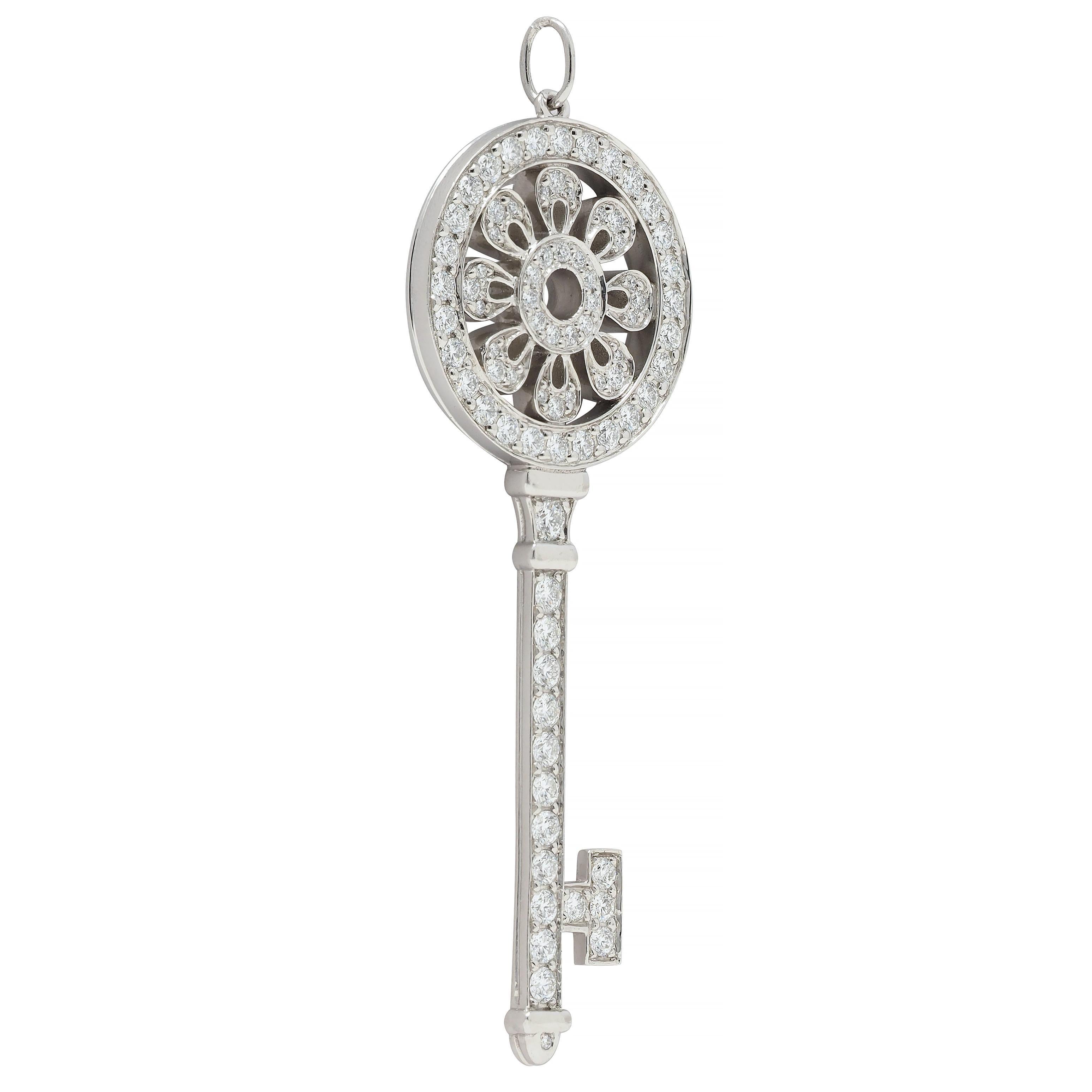 Designed as a stylized key with a pierced floral motif head 
Bead set throughout with round brilliant cut diamonds 
Weighing approximately 1.76 carats total 
G color with VS1 clarity 
Completed by jump ring bale 
Stamped for platinum
With maker's