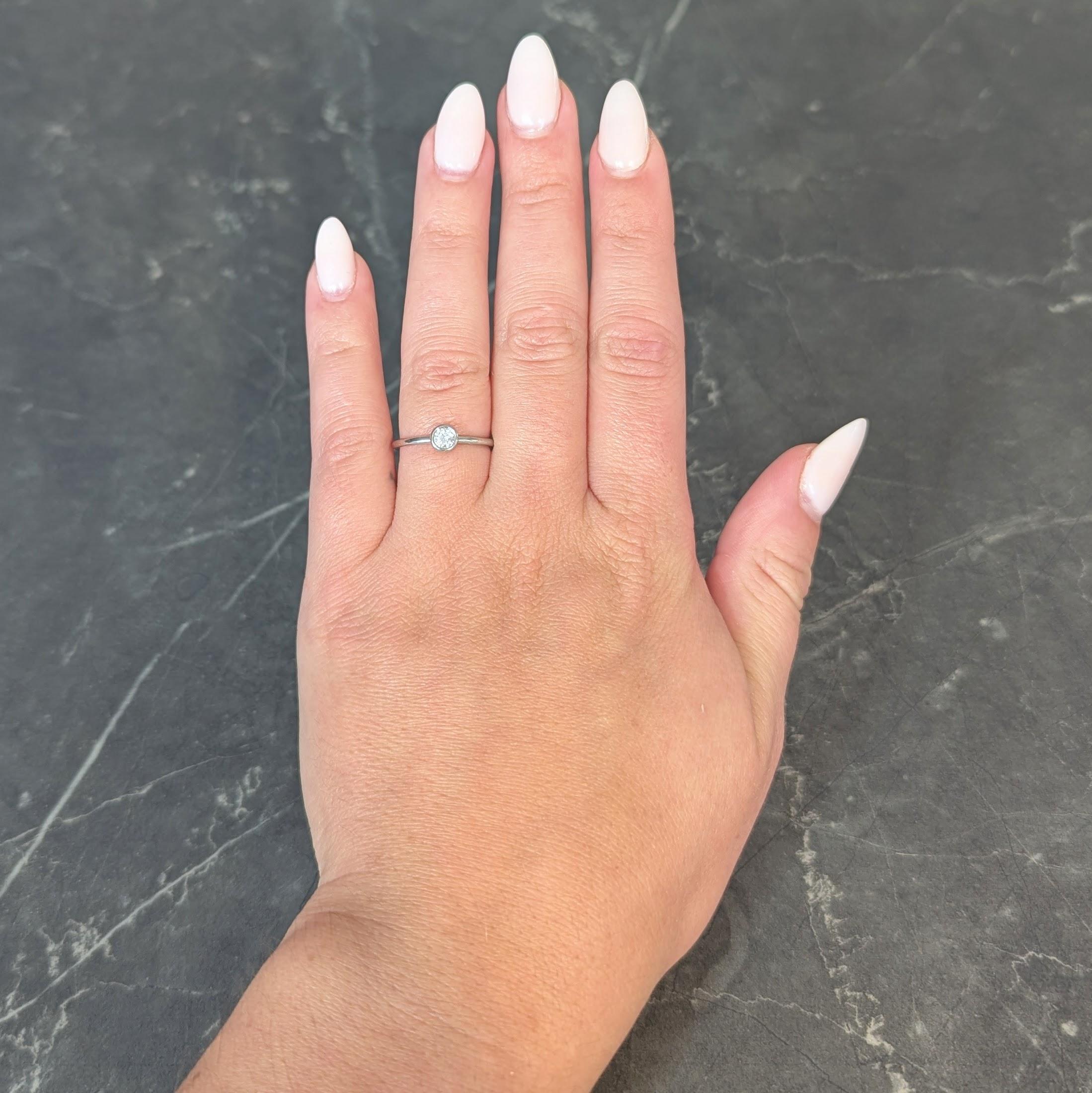 Centering a bezel set round brilliant cut diamond
Weighing approximately 0.15 carat
G/H color and VS clarity
Stamped for platinum
Fully signed Tiffany & Co.
Circa: 2000; via the Bezet Collection
Ring Size: 6 and sizable
Measures north to south 5.0