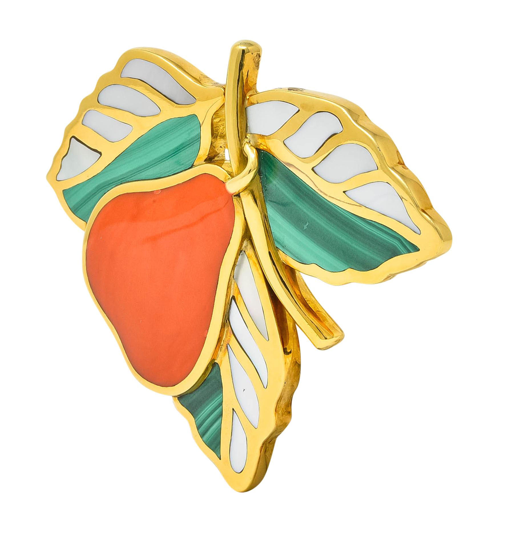 Brooch designed as a pear hanging from a polished gold branch, surrounded by three large leaves

Pear is comprised of a single piece of coral, inlaid in a polished gold surround, medium-light reddish-orange in color

Leaves are inlaid malachite,