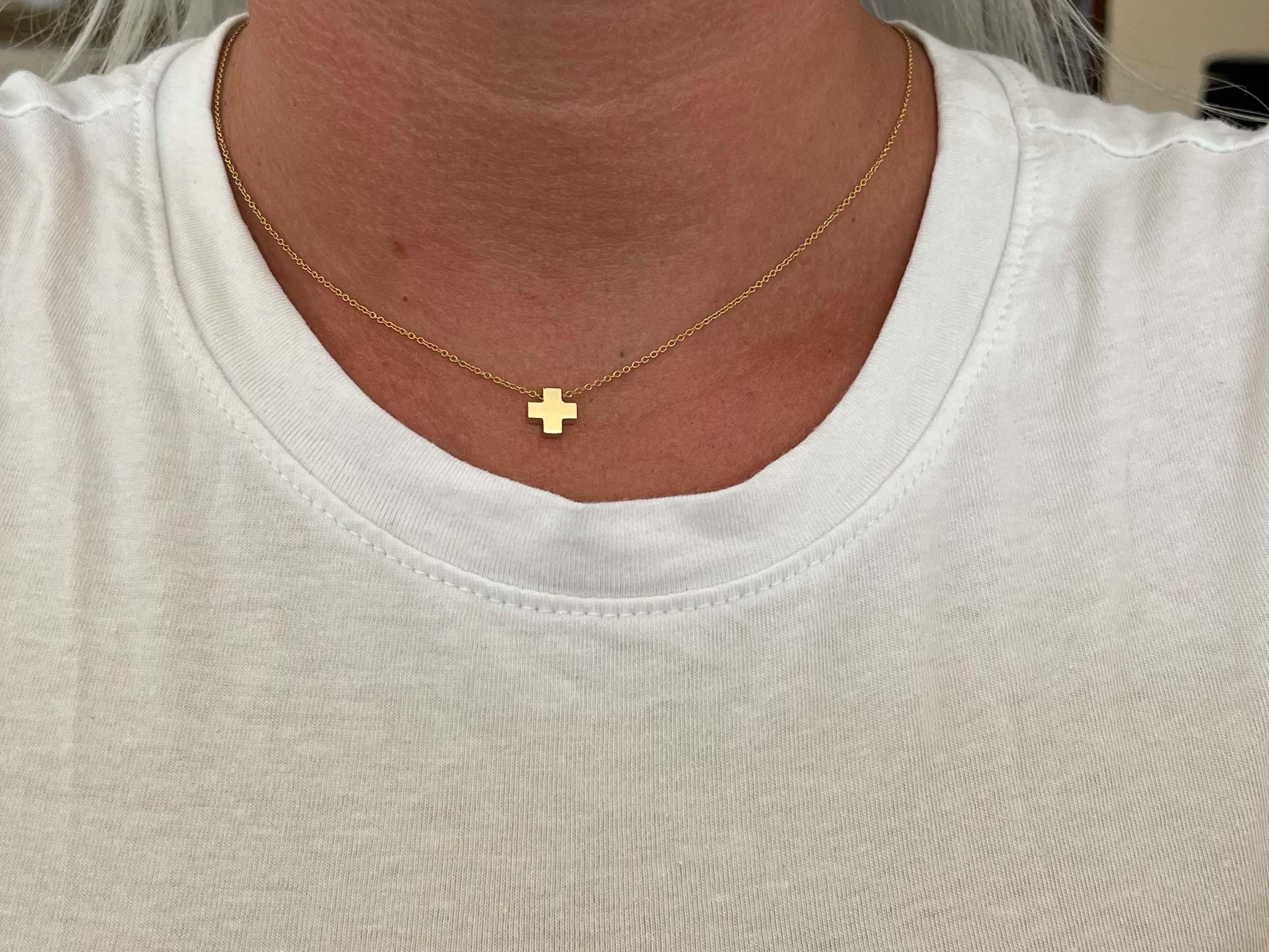 This cross pendant necklace is an ageless classic design by Tiffany & Co. This pendant and chain is richly crafted in 18k yellow gold. The pendant measures 8.16 mm in diameter and comes on a 16 inch Tiffany & Co. Rolo link chain. Altogether the