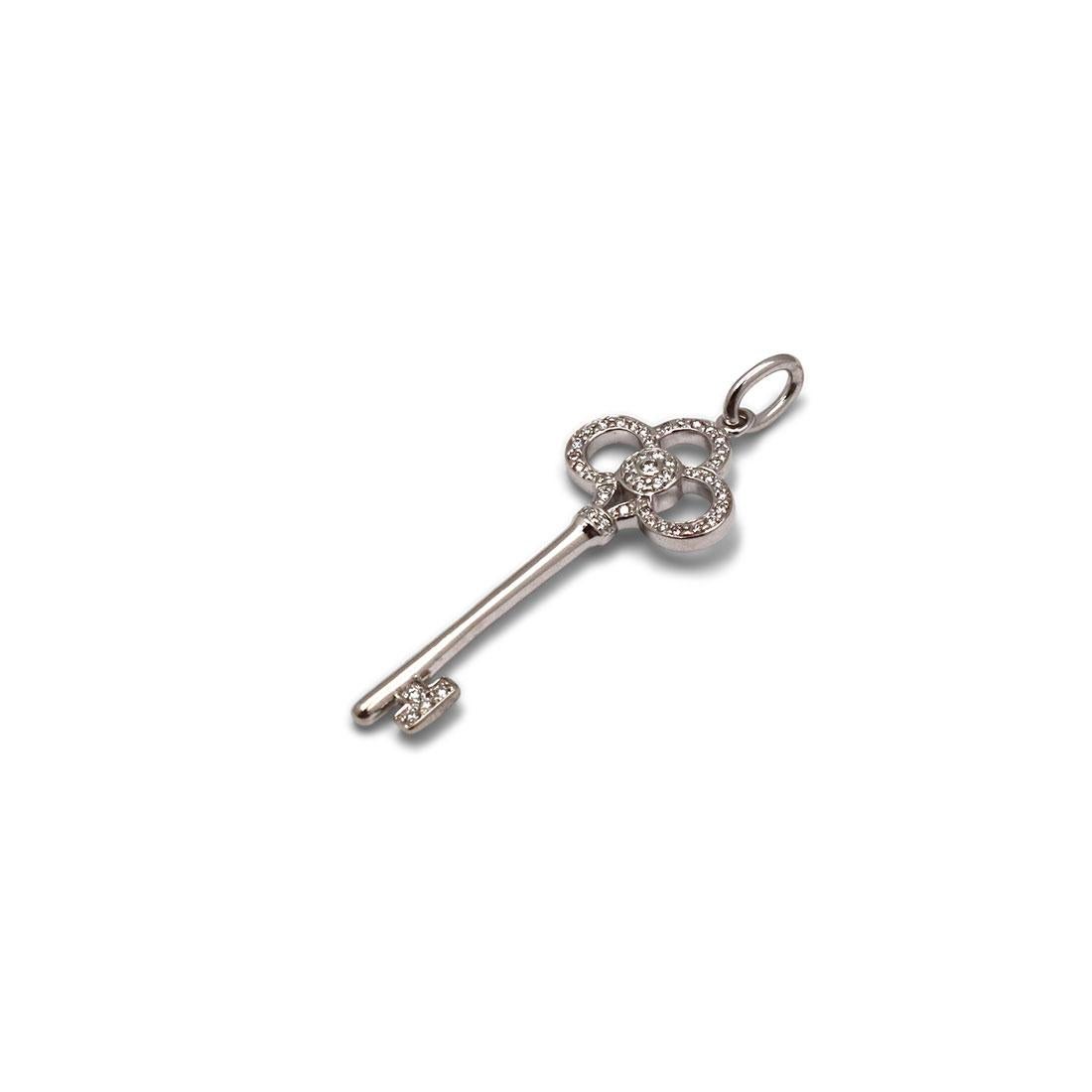 Authentic Tiffany & Co. 'Crown Key' pendant crafted in 18 karat white gold features and set with an estimated 0.13 carats of round brilliant cut diamonds (E-F, VS). This stunning pendant measures 1.5 inches in length. Signed Tiffany & Co., 750. The
