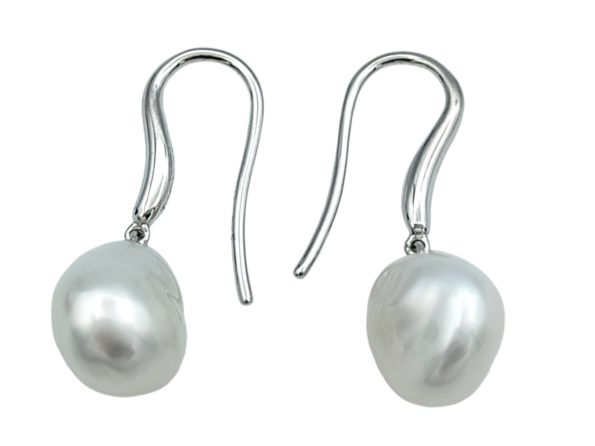Embrace the refined luxury of Tiffany & Co. with these exquisite baroque pearl drop earrings, masterfully crafted in platinum. Each earring features a lustrous cultured freshwater pearl, celebrated for its unique shape and radiant luster, adding a