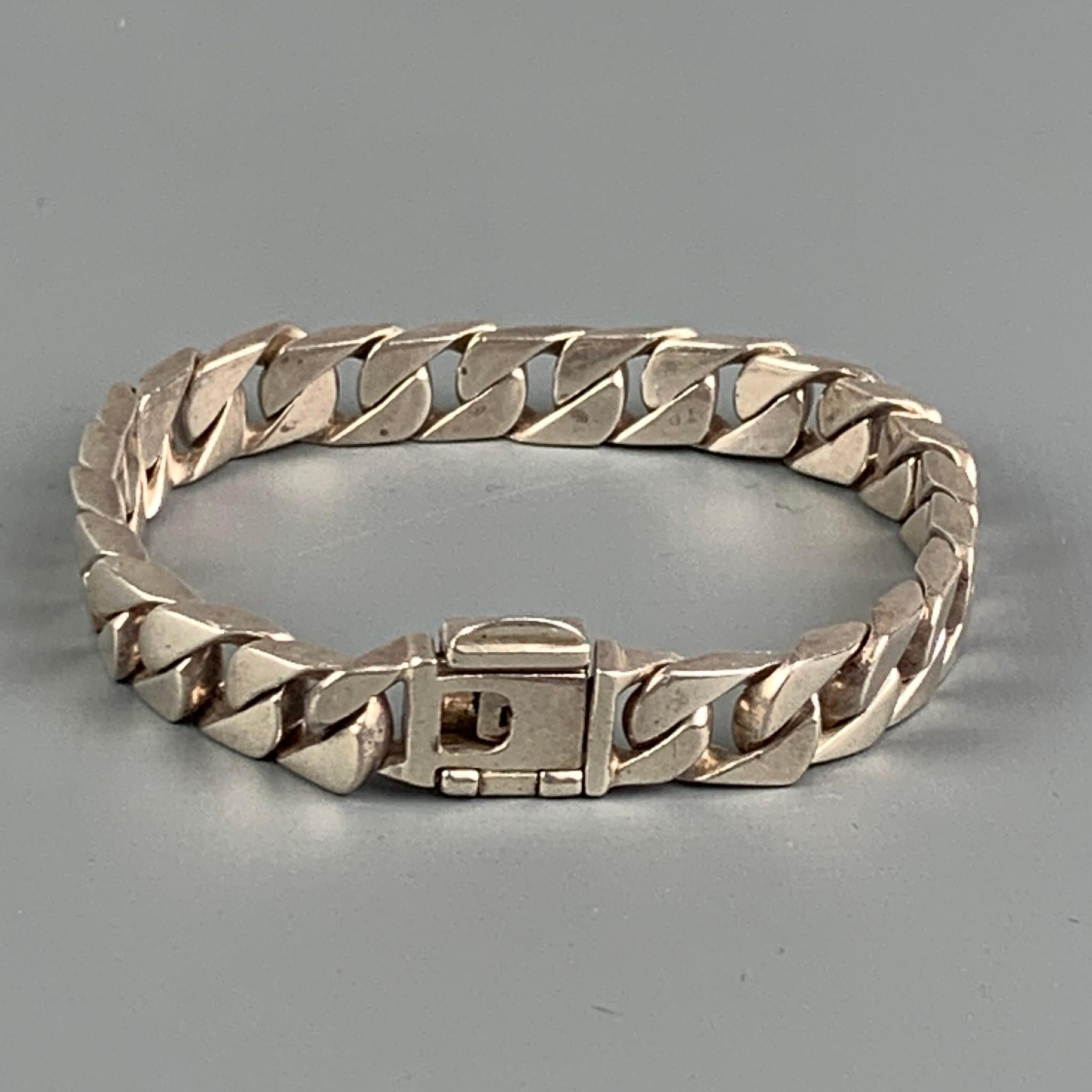 TIFFANY & CO. curb link bracelet comes in a sterling silver featuring a clasp closure. Includes pouch. Made in Italy. 

Very Good Pre-Owned Condition.

Measurements:

Length: 7.5 in. 
Width: 0.5 in. 