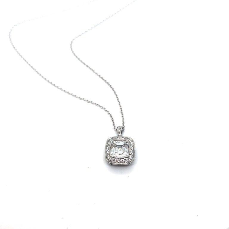 Estate Tiffany & Co. platinum chain and pendant set with a center cushion modified brilliant cut diamond, surrounded by 18 round brilliant cut diamonds. The center diamond is of H color and VVS1 clarity and weighs 1.13cts. The surrounding diamonds