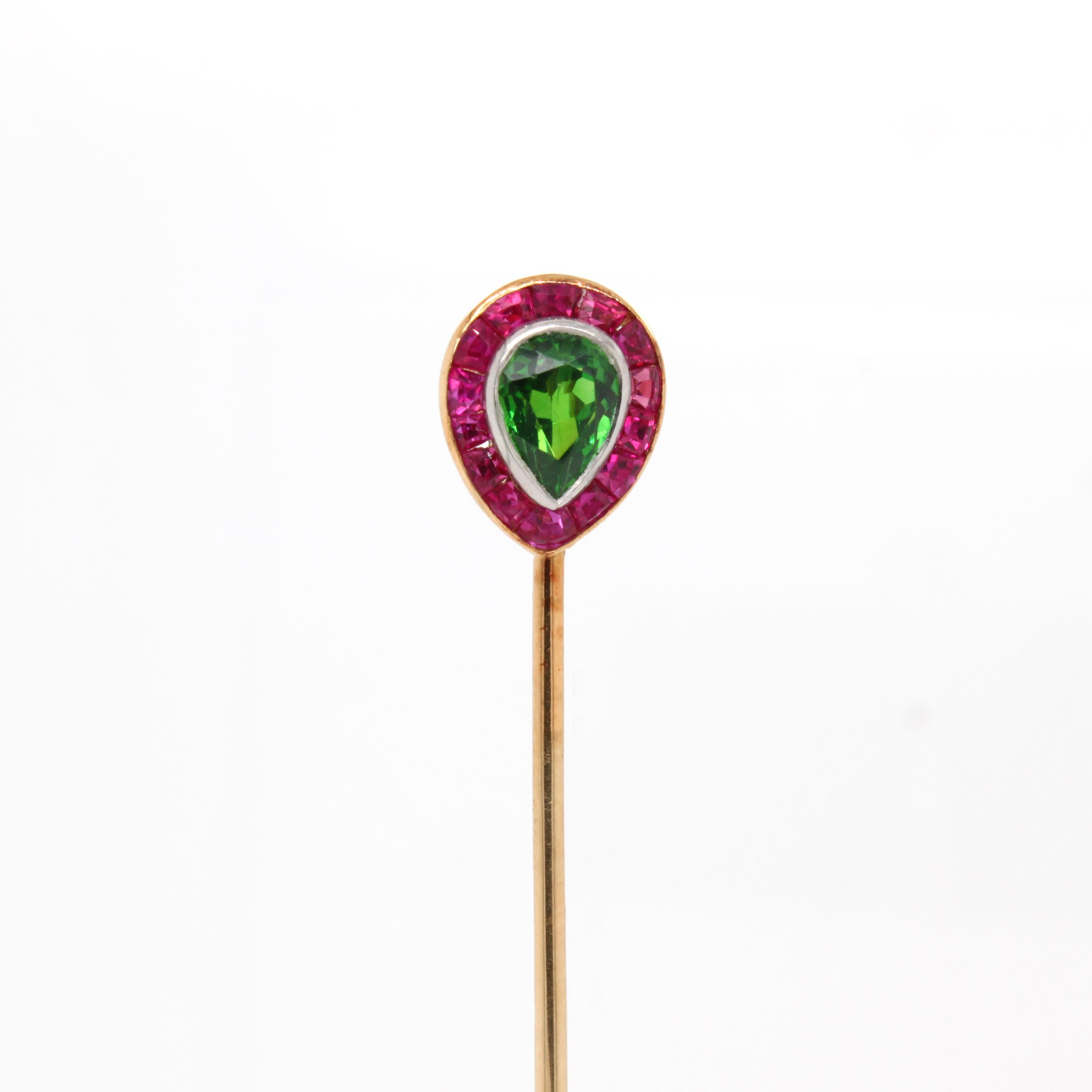 Tiffany & Co Russian Demantoid and Ruby Pin, ca. 1940s

A very delightful stick pin for every situation. The jewel centres a very bright Russian demantoid (with some horsetail features) and is surrounded by a cluster of bright square and taper cut