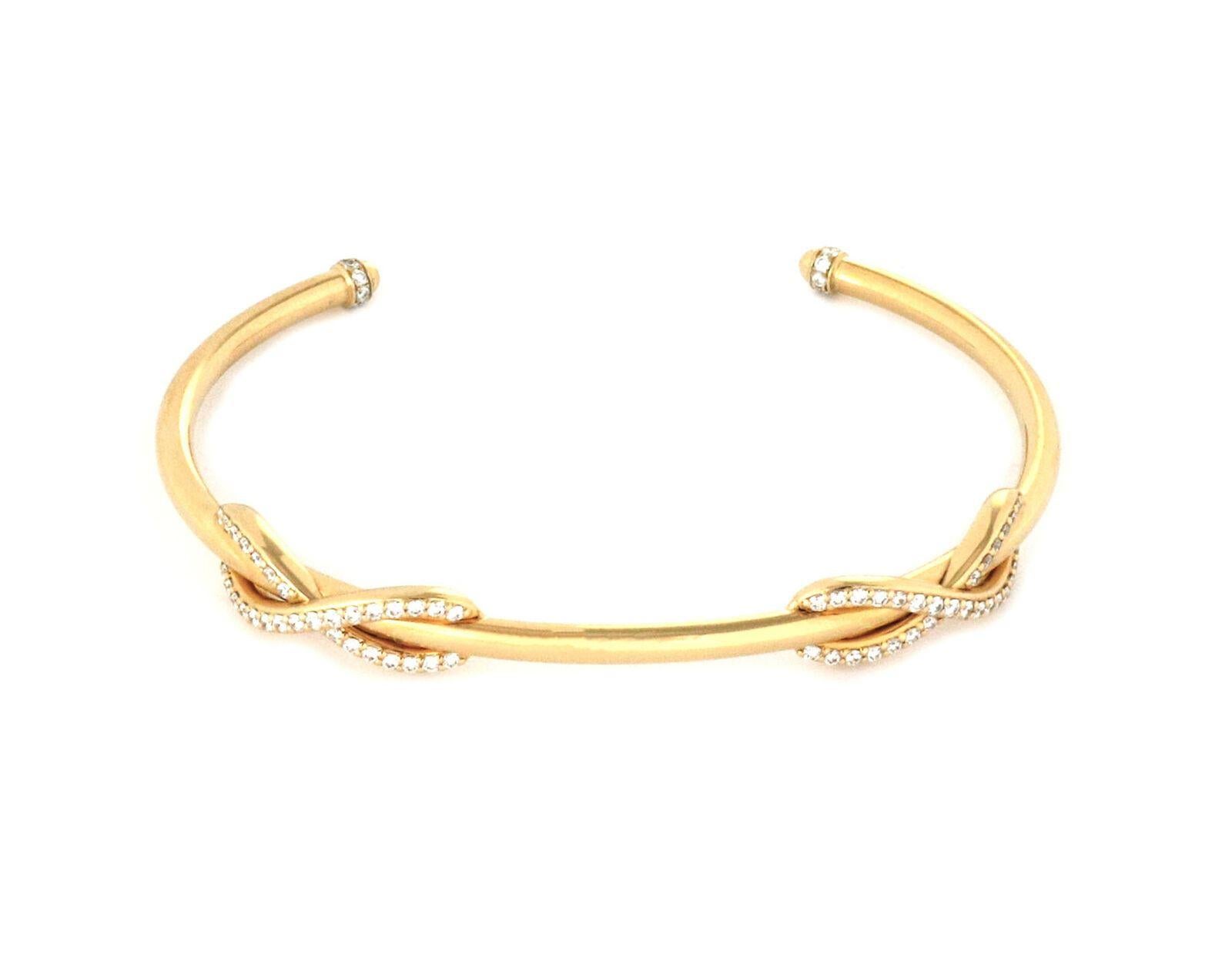 This is a gorgeous cuff bracelet by Tiffany & Co. from the Infinity Collection. It is crafted from 18k yellow gold featuring a thick wire cuff with two infinity design on the front decorated with 65 points diamonds. The two end of the bangle has