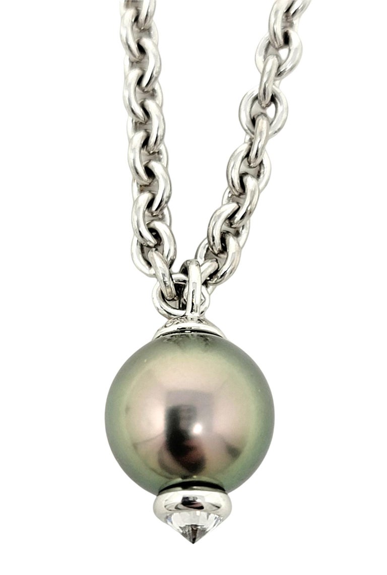 This exquisite Tiffany & Co. diamond and Tahitian pearl pendant necklace exudes understated elegance. The incredible cultured black pearl has a gorgeous iridescent aura that absolutely glows on the neck. A single icy white Tiffany diamond perfectly