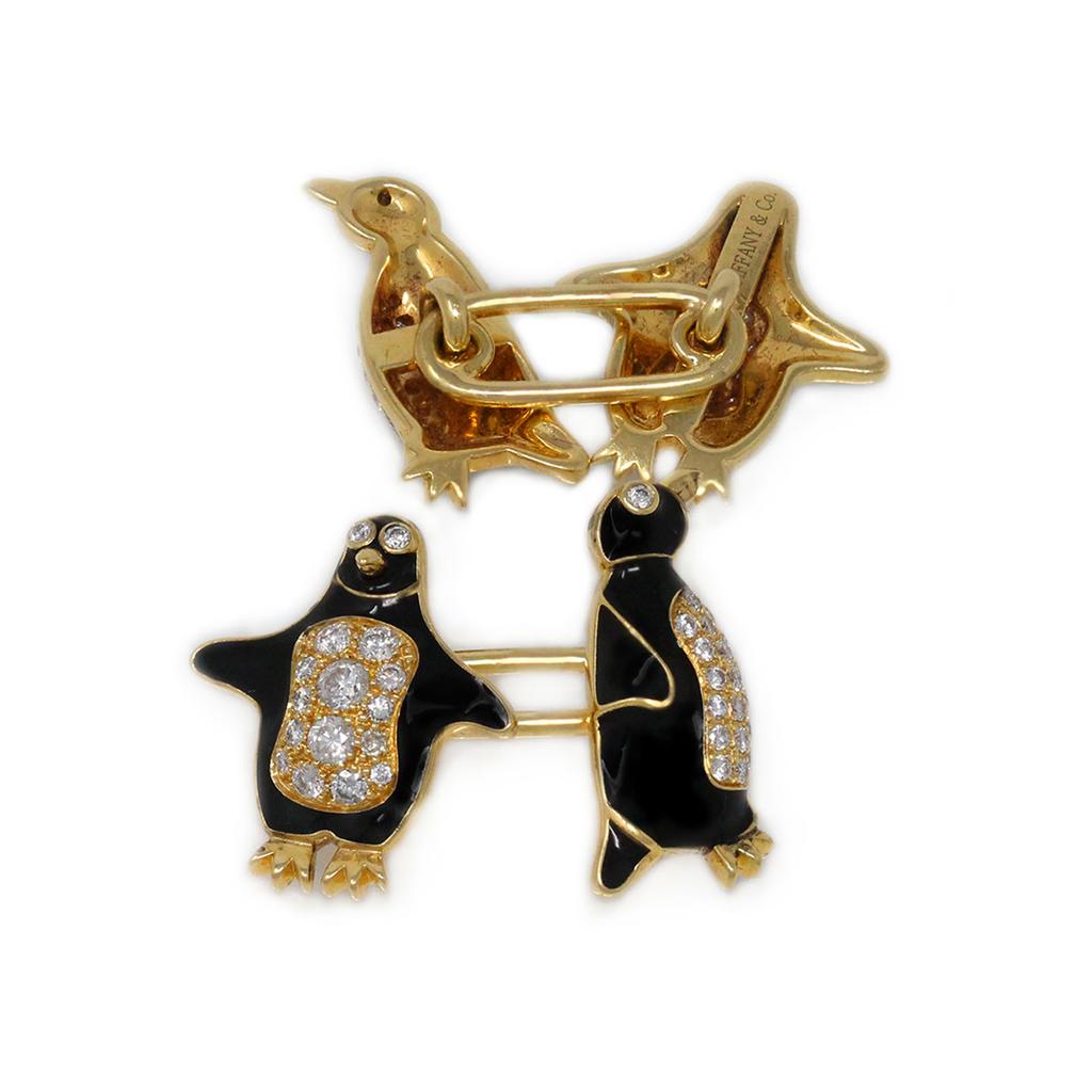 The playful Penguins Cufflink and Studs set signed by the iconic house of jewelry Tiffany and Company is made in 18 karat yellow gold, pavé set diamonds and black enamel. It includes a pair of cufflinks and three shirt studs. The diamonds are graded