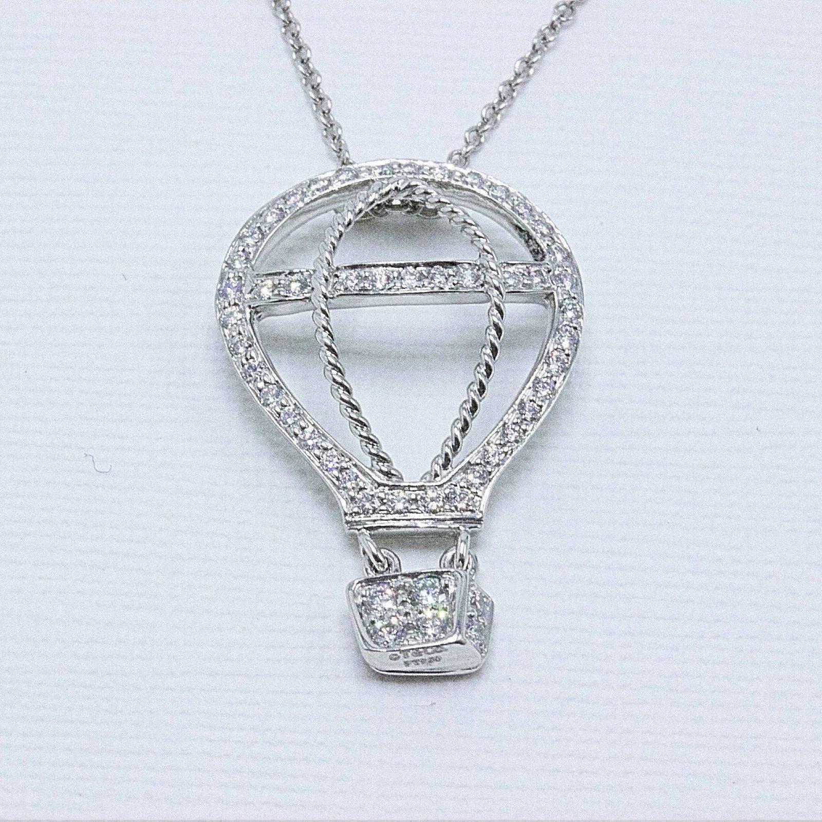 Tiffany & Co.
Style:  Diamond Hot Air Balloon Pendant Necklace
Sku Number:  18411972
Metal:  Platinum PT950
Length:  15 Inches Rolo Chain & 1 Inch Pendant
Total Carat Weight:  0.33 TCW
Diamond Shape:  Round Brilliant
Diamond Color & Clarity:  F-G /