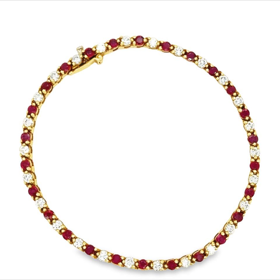 A classic riviere bracelet made by famed jewelry company Tiffany & Co. The bracelet is crafted in 18k yellow gold with alternating scintillating diamonds and ruby gemstones. The diamonds are E-F color and display VVS clarity, the rubies are a