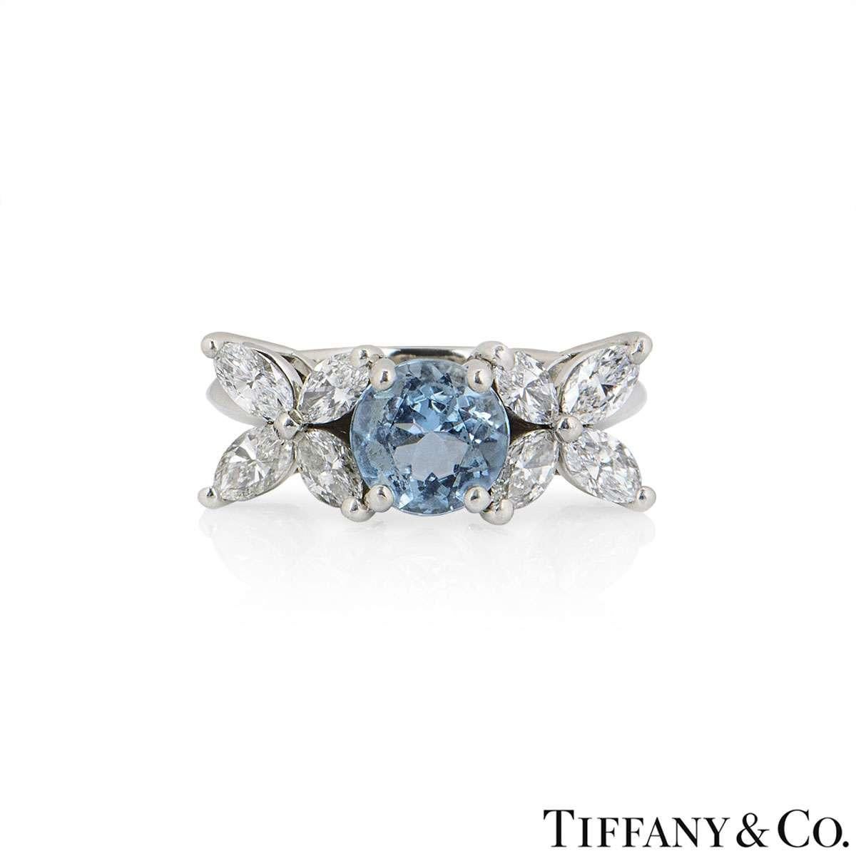 A diamond and aquamarine ring in platinum from the Victoria collection by Tiffany & Co. The ring is set to the centre with a round cut aquamarine weighing approximately 1.00ct. The stone is flanked by 4 marquise cut diamonds on either side, with a