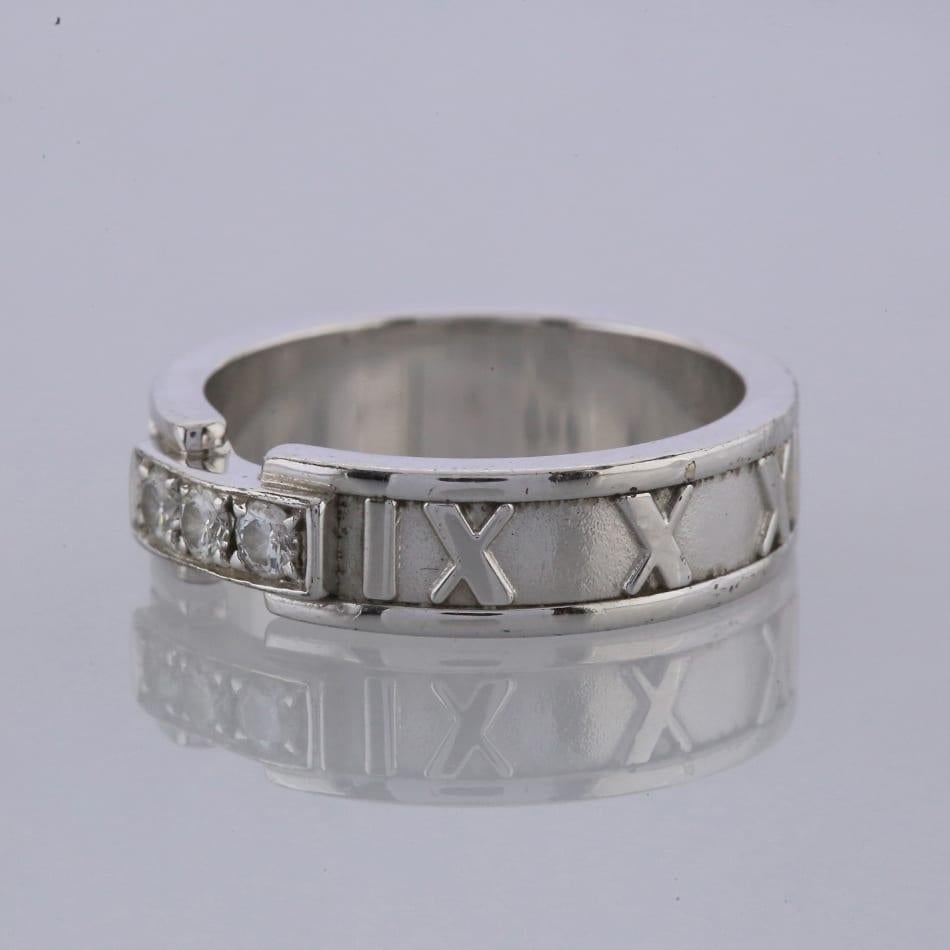 Dies ist ein Ring aus 18 Karat Weißgold aus der Atlas Collection'S von Tiffany. Der Ring ist mit 3 Diamanten besetzt, die auf der Vorderseite des Bandes liegen. Das Band ist mit römischen Ziffern in klassischer 