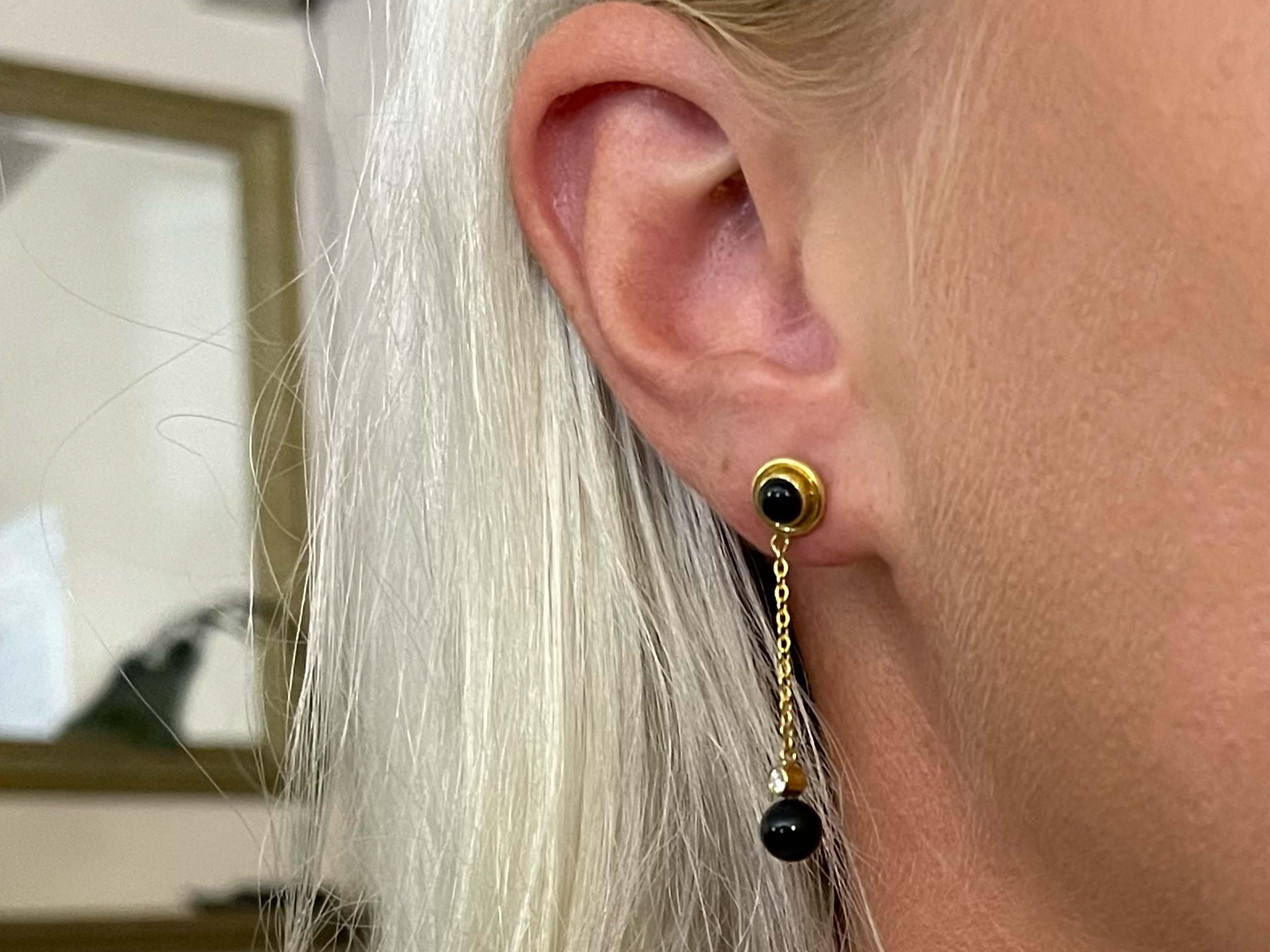 Tiffany & Co. Diamond & Black Onyx Dangle Earrings in 18k Yellow Gold.  Classic and elegant these earrings feature a gold stud bezel set with a black cabochon round onyx.  Suspended from the stud by a thin cable link chain is a bezel set round