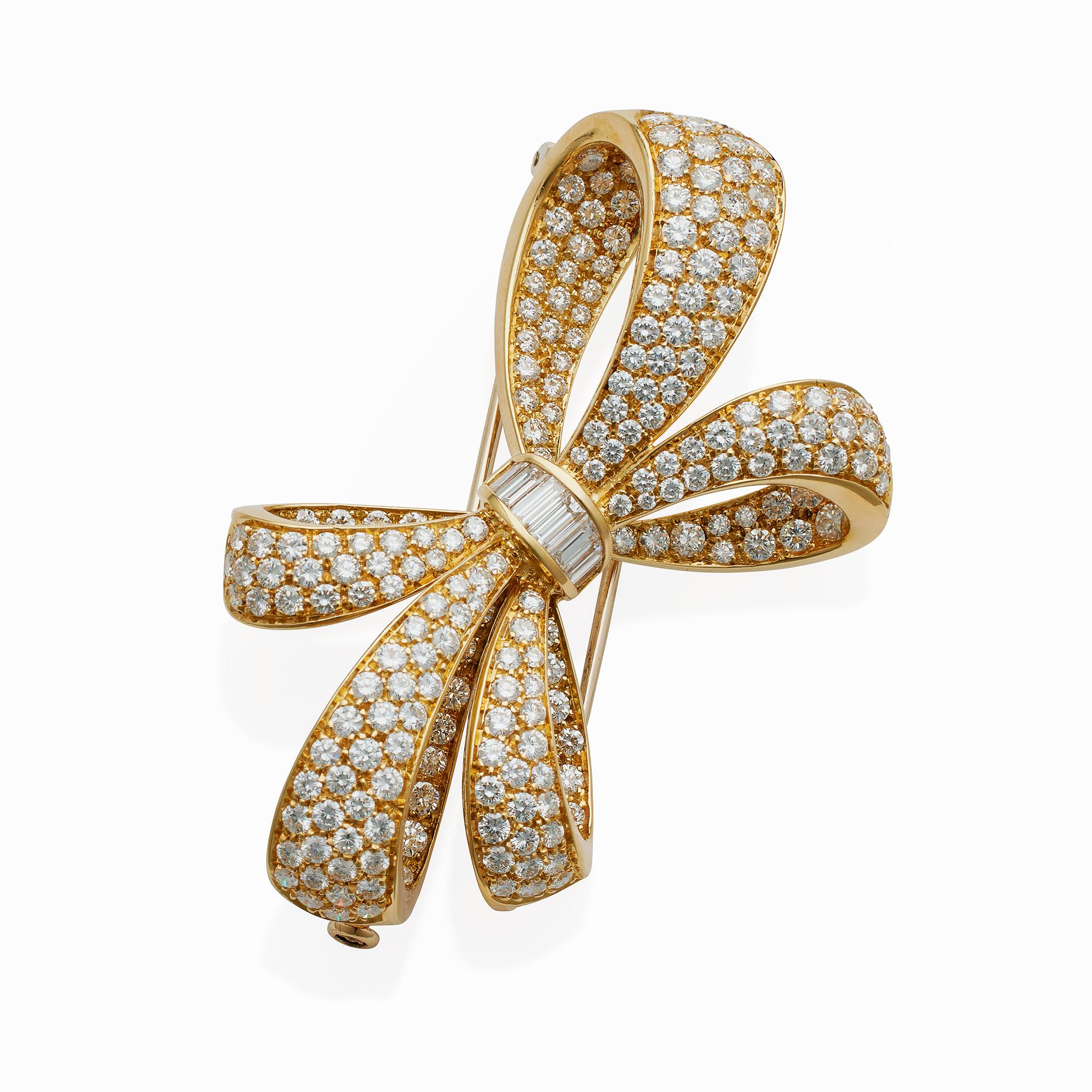 Dating from circa 1997, this 18K gold Tiffany & Co. bow brooch is set with over 7 carats of diamonds. It is designed as a highly three dimensional bow of five loops pavé-set throughout with round brilliant-cut diamonds, its center channel-set with a
