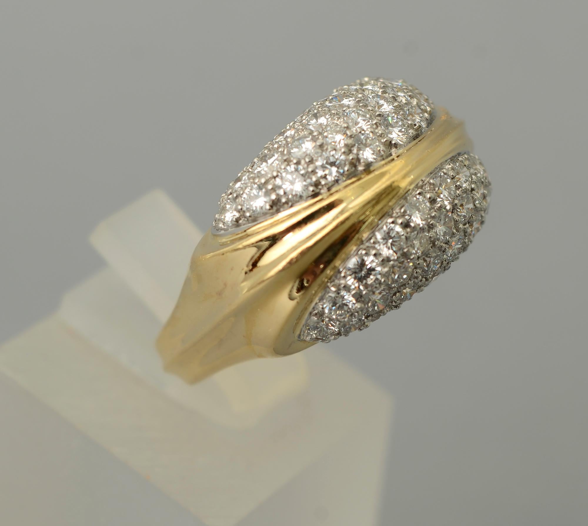 Elegant diamond cocktail ring by Tiffany and Co. The 18 karat ring has approximately 3 carats of VS 1 diamonds; H  color. A gold band that is integrated as part of the design of the entire ring separates two groups of diamonds.
The ring is size 7