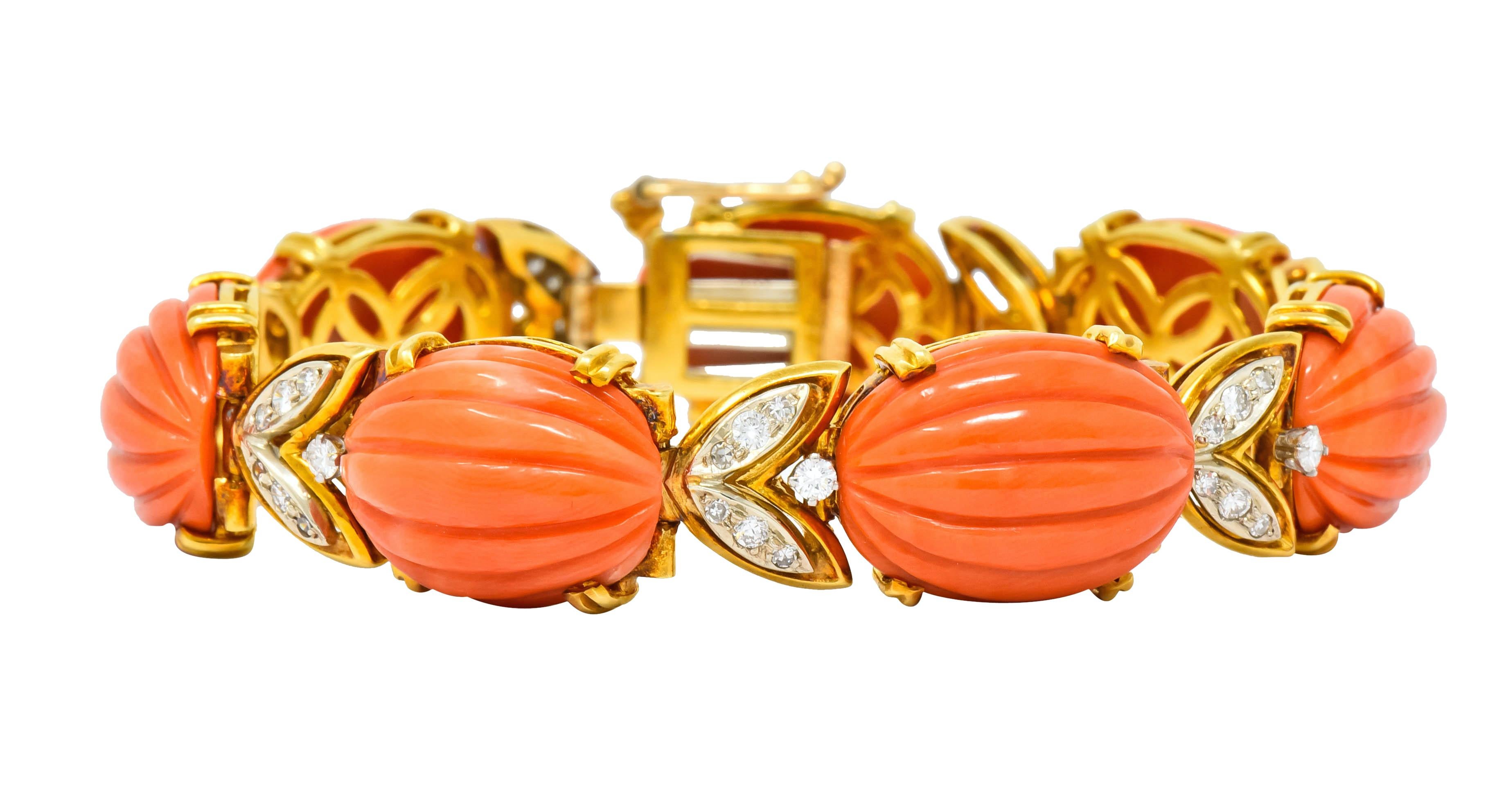 Bracelet comprised of oval coral cabochon links, deeply ridged and prong set, very well-matched orangey-pink in color

With platinum-topped foliate spacer links set with round brilliant cut and single cut diamonds weighing approximately 0.91 carat