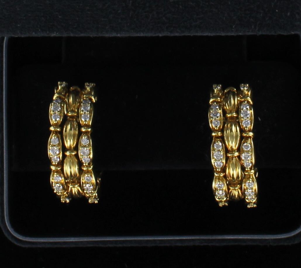 These Tiffany and Co. diamond half-hoop earrings are impossible to miss.   The earrings consist of three gold vertical rows, the outside two being set with 3.0 carats total weight of diamonds.   These magnificent earrings are 1 1/4 inch long and 3/8