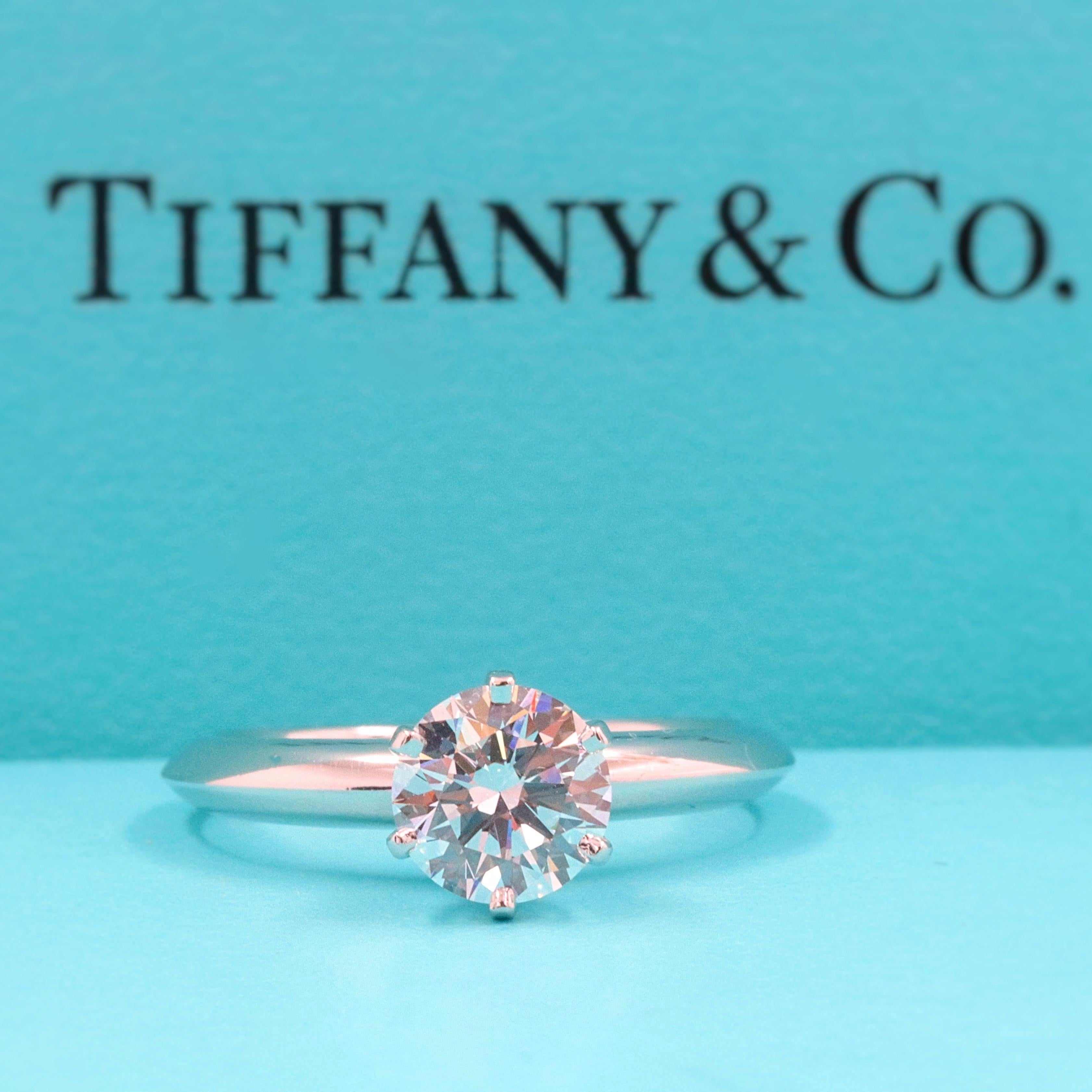 Tiffany & Co 
Classic Six Prong Solitaire Engagement Ring in Platinum.... 
Round Brilliant Cut Diamond is a 0.96 CTS E color, VS1 Clarity.  
Size 6 - sizable.  
Diamond has crown inscription 