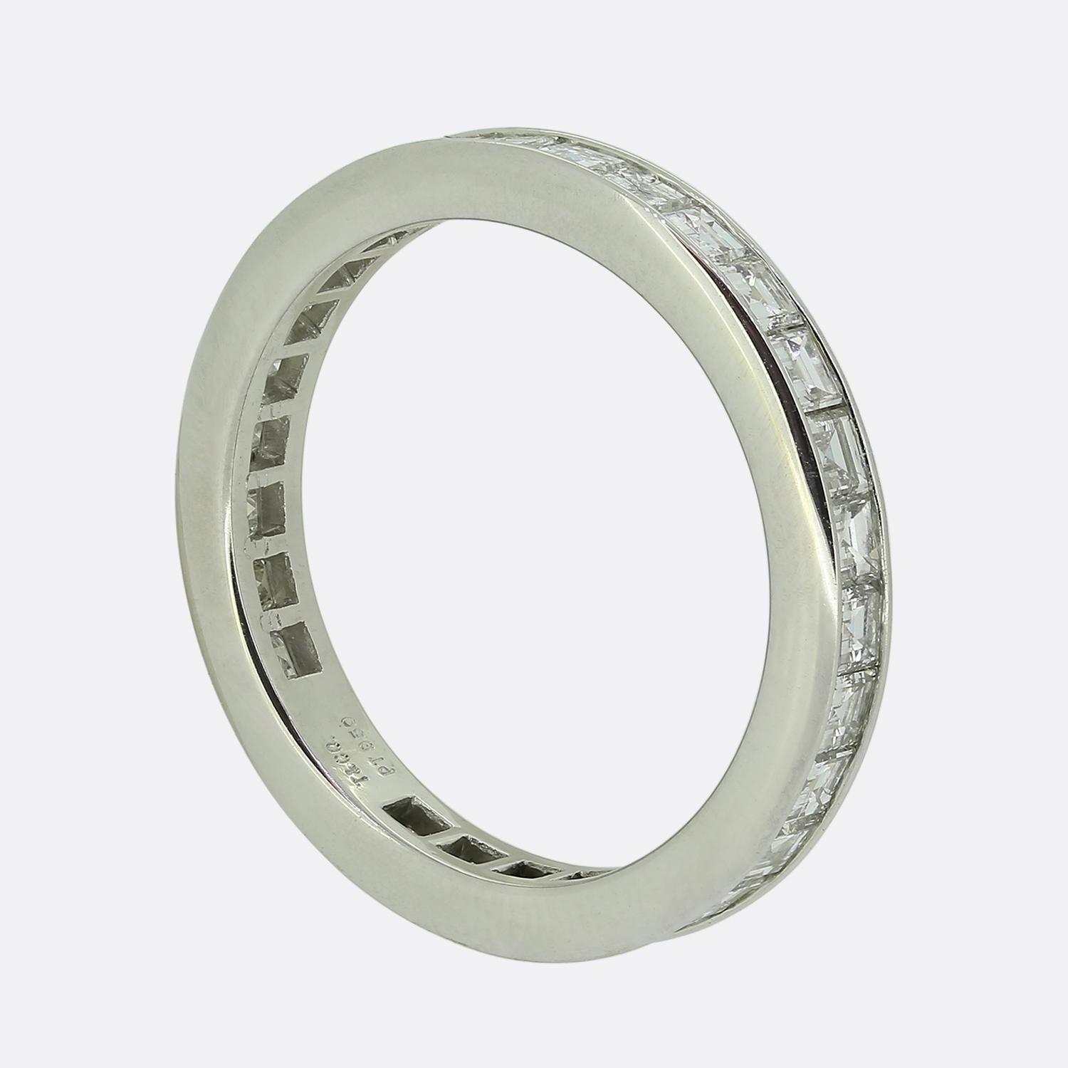 Here we a classically styled diamond eternity ring from the world renowned jewellery designer, Tiffany & Co. This vintage platinum piece features 29 carre cut diamonds; all of which have been bezel set in a single line formation to wrap around the