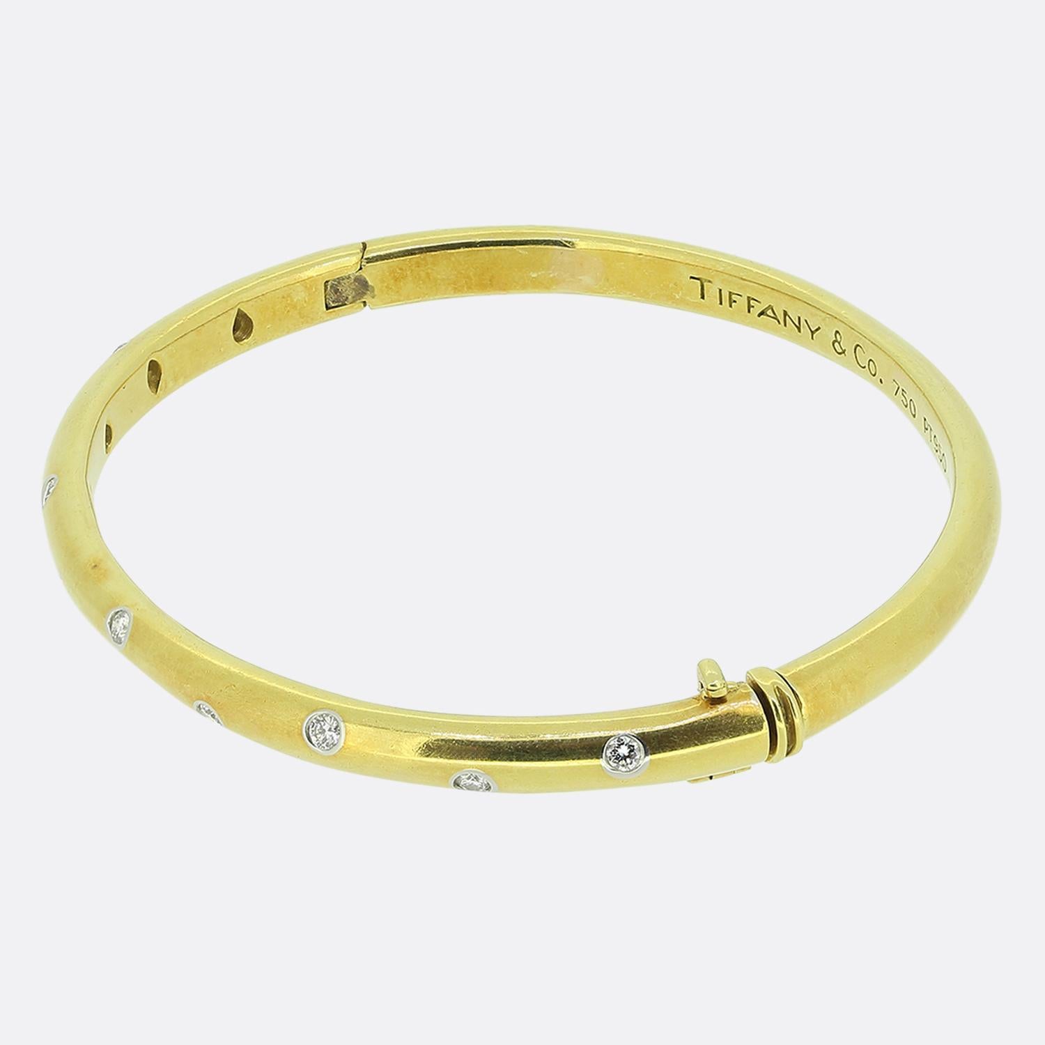 Here we have an iconic diamond bangle from the world renowned jewellery designer, Tiffany & Co. This rich 18ct yellow gold piece forms part of their Etoile collection and features 10 round brilliant cut diamonds; each of which has been individually