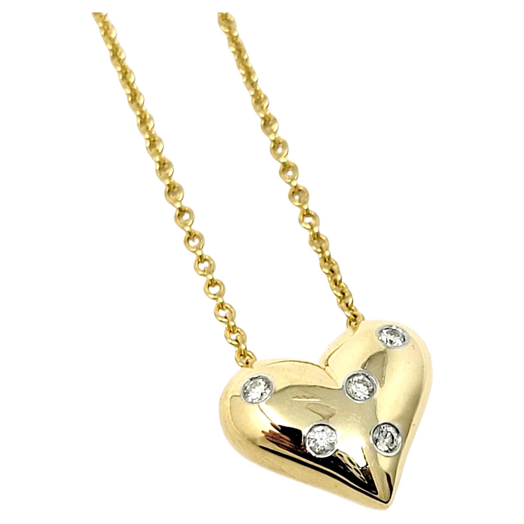 Absolutely gorgeous Etoile diamond heart pendant necklace from Tiffany & Co.. Dazzling round diamonds are scattered throughout this solid gold heart, offering sparkle from all angles. The feminine, romantic style radiates on the neck, while the