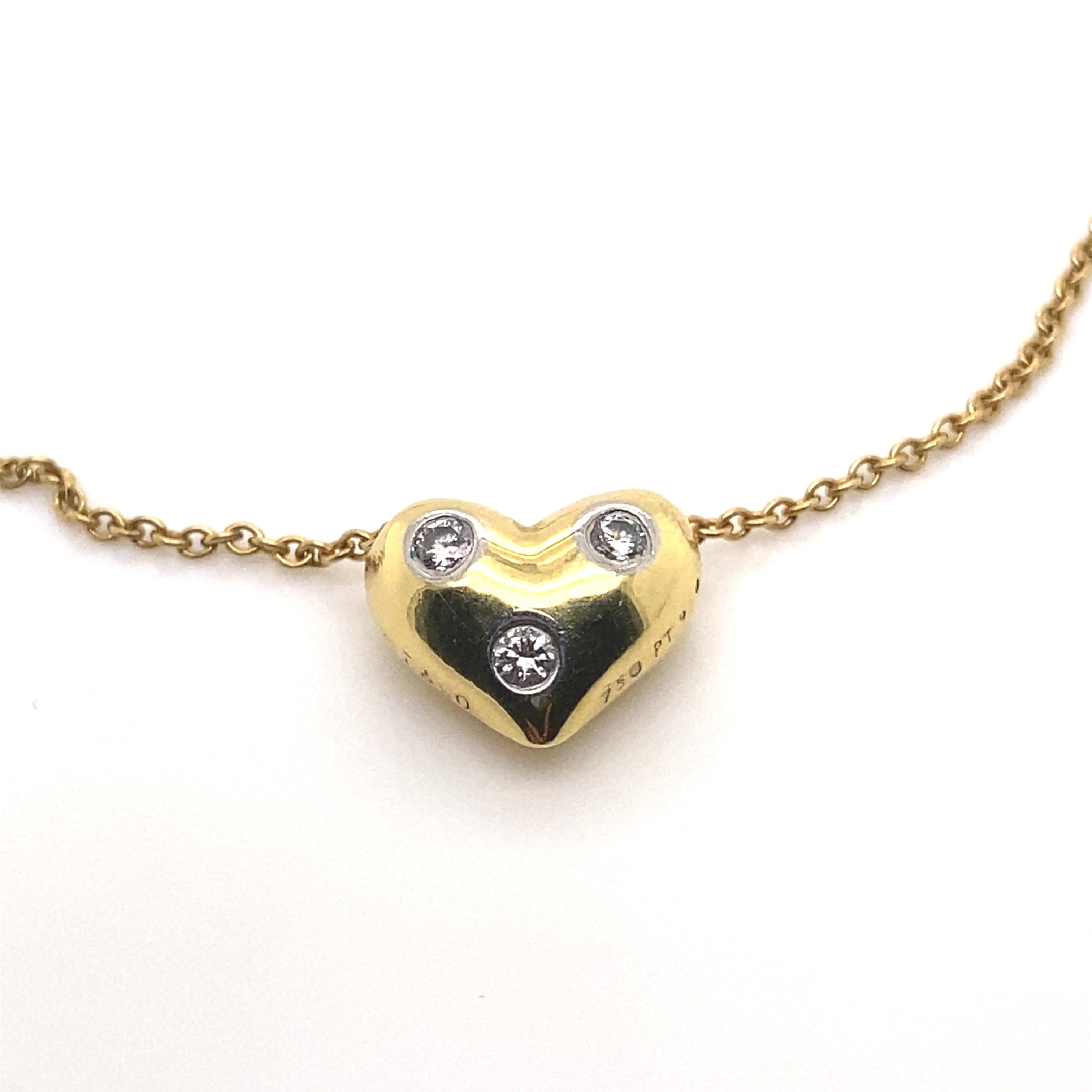 A Tiffany & Co. diamond Etoile heart shaped pendant necklace in 18 karat yellow gold.

This sweet heart shaped pendant features three diamonds scattered throughout the solid gold heart, each set within a fine circular platinum bezel - to enhance the