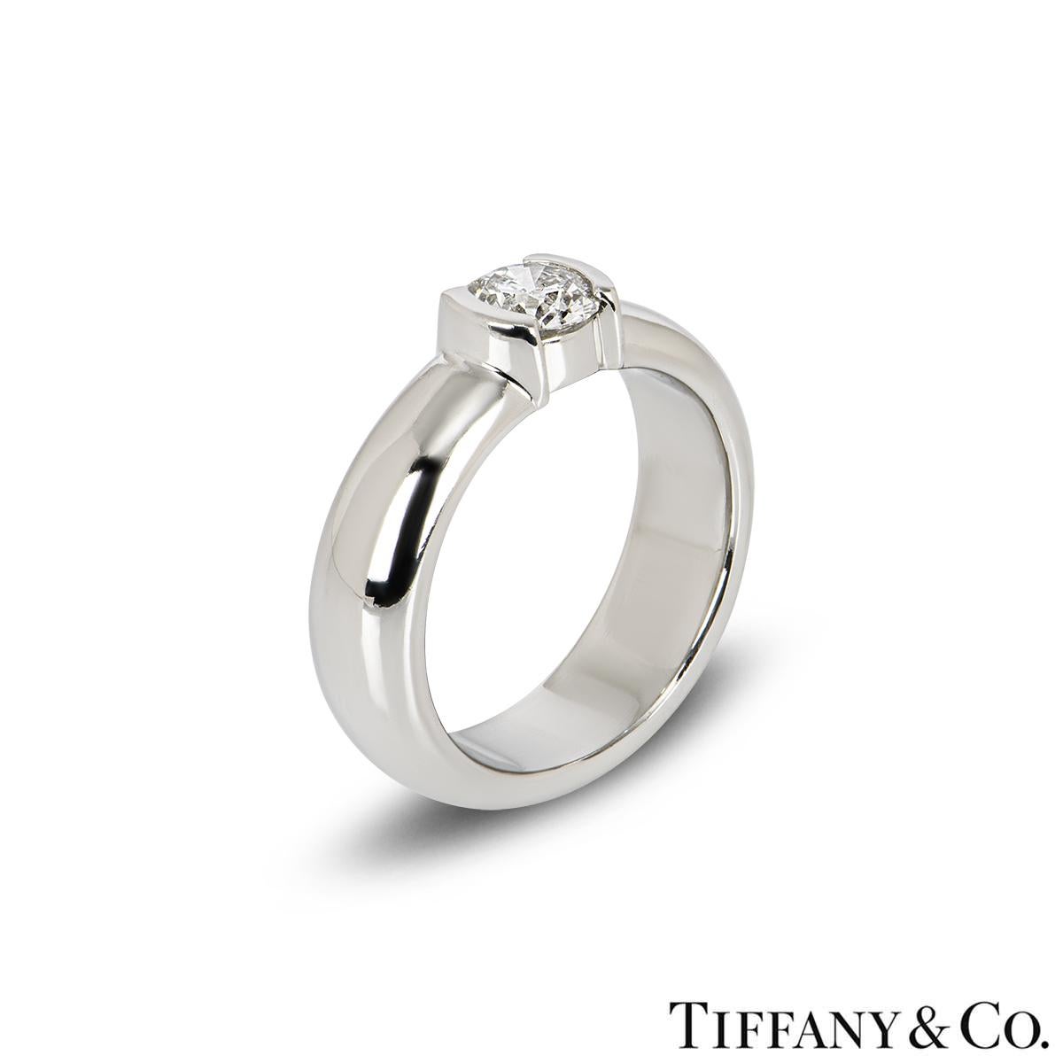 A beautiful platinum Tiffany & Co. diamond ring from the Etoile collection. The ring is set to the centre with a 0.50ct round brilliant cut diamond, F colour and VS1 in clarity, set in a raised open tension setting. The 5mm ring has a gross weight