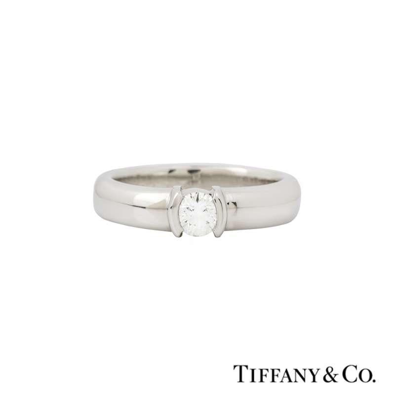 A diamond ring in platinum from the Tiffany & Co. Etoile collection. The ring is set to the centre with a 0.23ct round brilliant cut diamond, G/H colour and VS2 in clarity set in a raised, open tension setting. The 4mm ring is a size UK J/US 4.75/EU