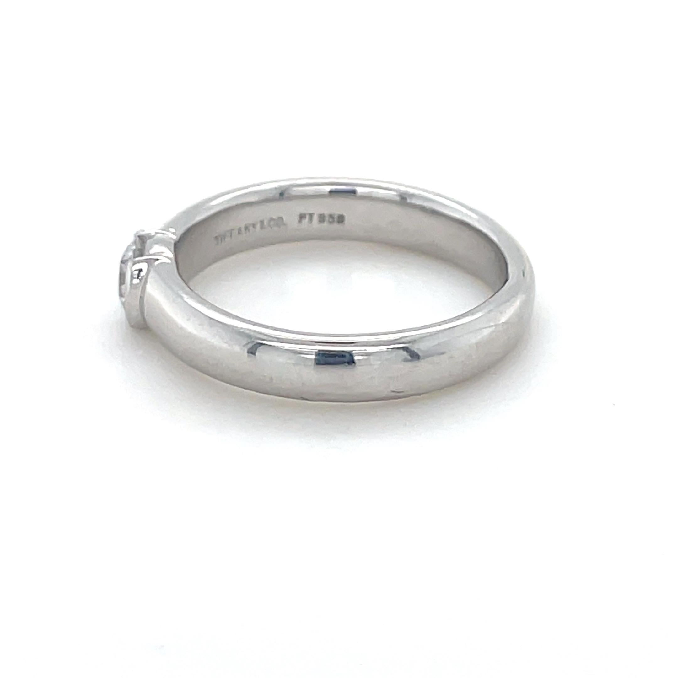 Este anillo clásico de Tiffany & Co., de su colección Etoile, presenta un diamante redondo de talla brillante de 0,28 quilates engastado en medio bisel. Montado en platino con artesanía de primera calidad, ¡este anillo es perfecto para tu
