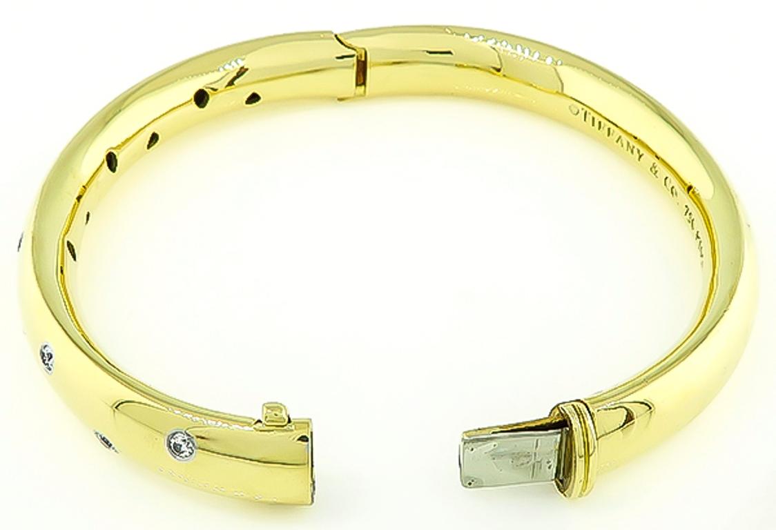 Made of 18k yellow gold and platinum, this Tiffany & Co bangle is set with sparkling round cut diamonds that weigh approximately 0.40ct. graded E-F color with VS clarity. The bangle measures 9mm in width and will fit a standard wrist size.
It is