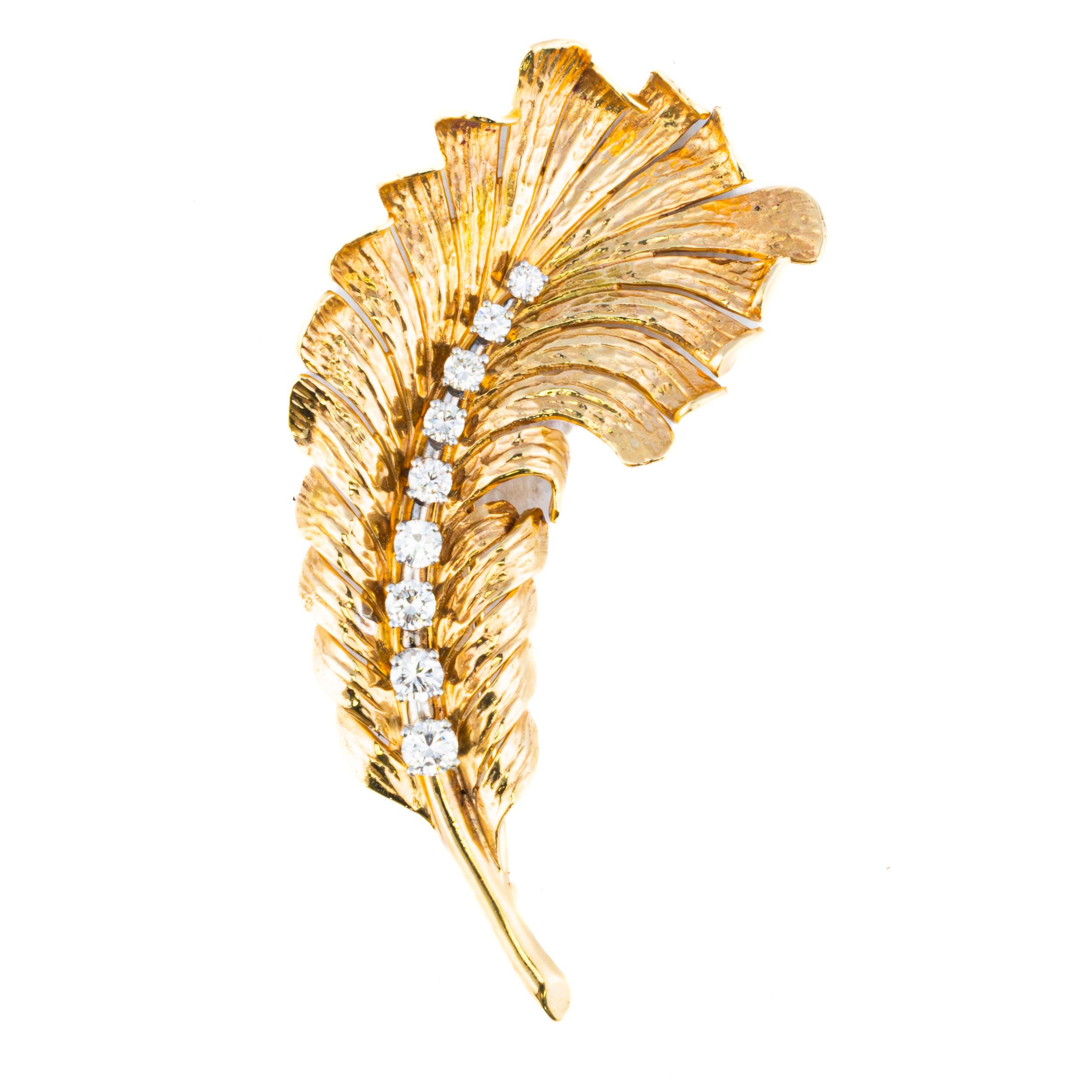 A timeless creation from Tiffany & Co., this elegant feather brooch is masterfully crafted in 18k yellow gold, exuding a sense of natural grace and sophistication. The delicately sculpted feather motif is enhanced by a flowing row of brilliant-cut