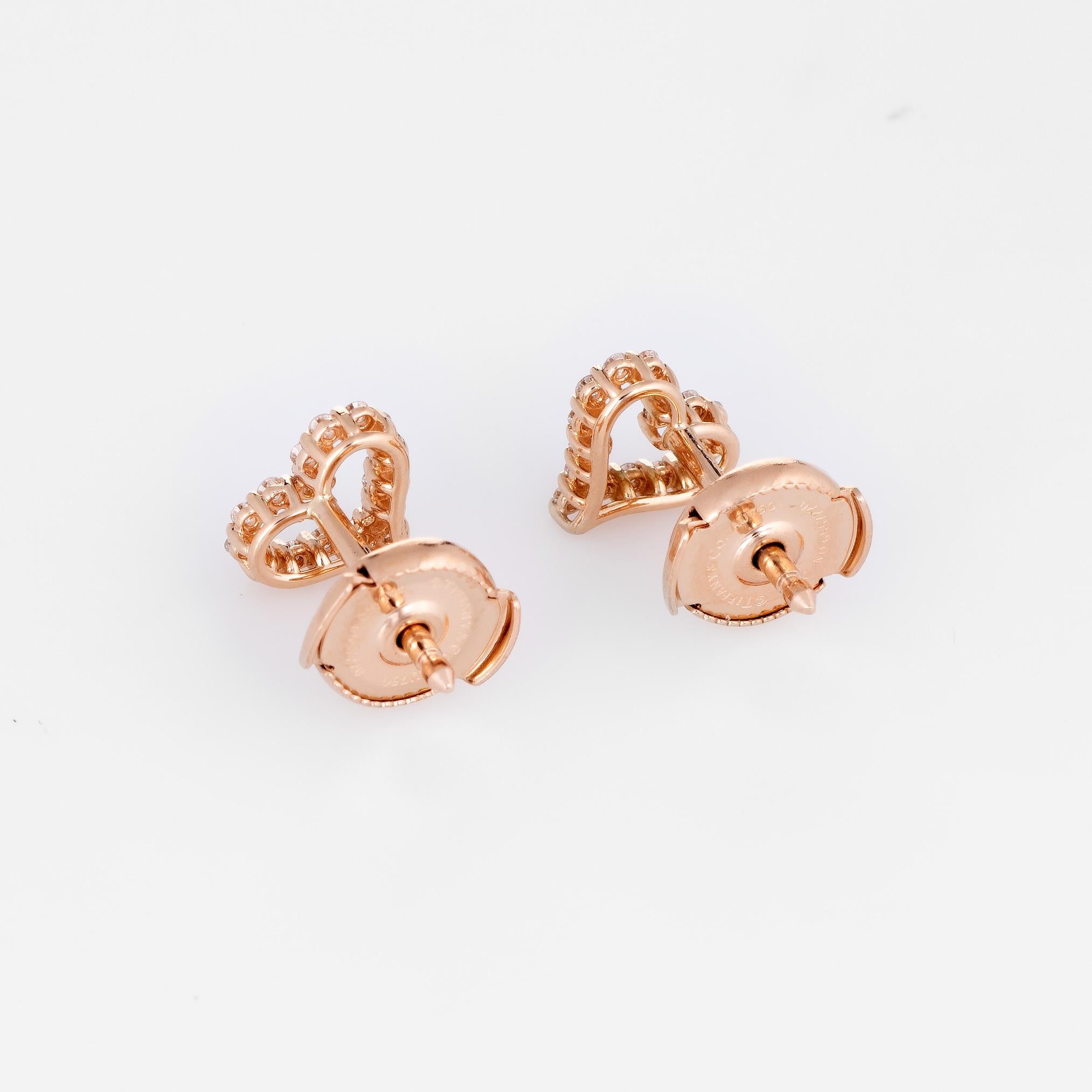 Elegant pair of Tiffany & Co diamond heart earrings crafted in 18k white gold. 

Round brilliant cut diamonds total 0.13 carats (estimated at F-G color and VVS2 clarity). 

The 'extra mini' earrings by Tiffany & Co are crafted in 18k rose gold and