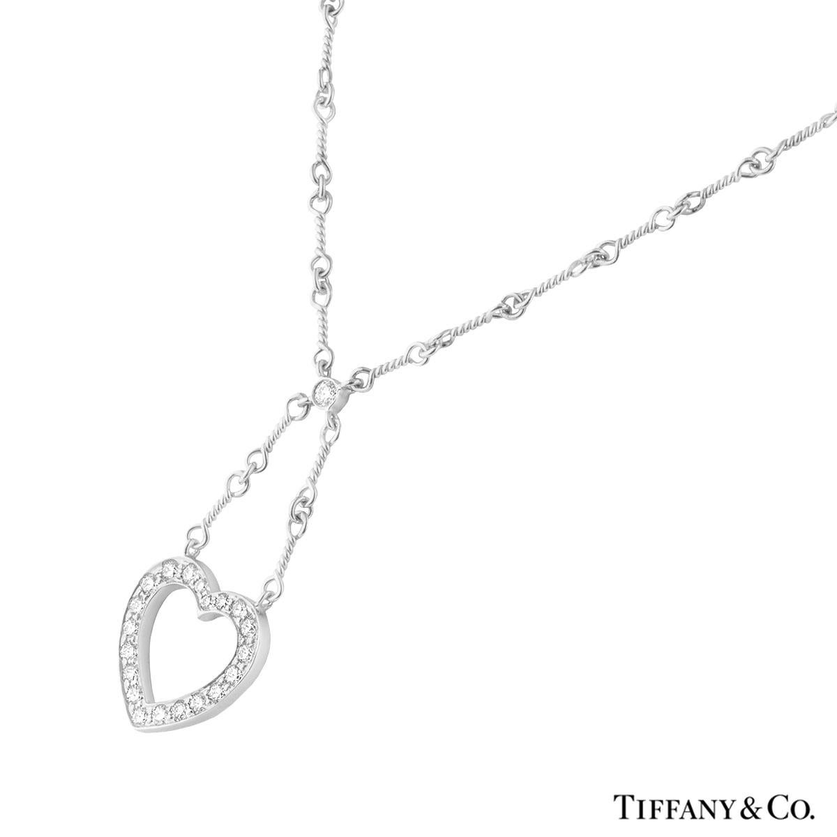 An elegant diamond necklace in platinum by Tiffany & Co. The necklace is set with a single round brilliant cut diamond leading on to an open work heart motif, pave set with 20 round brilliant cut diamonds totalling approximately 0.65ct, G colour and
