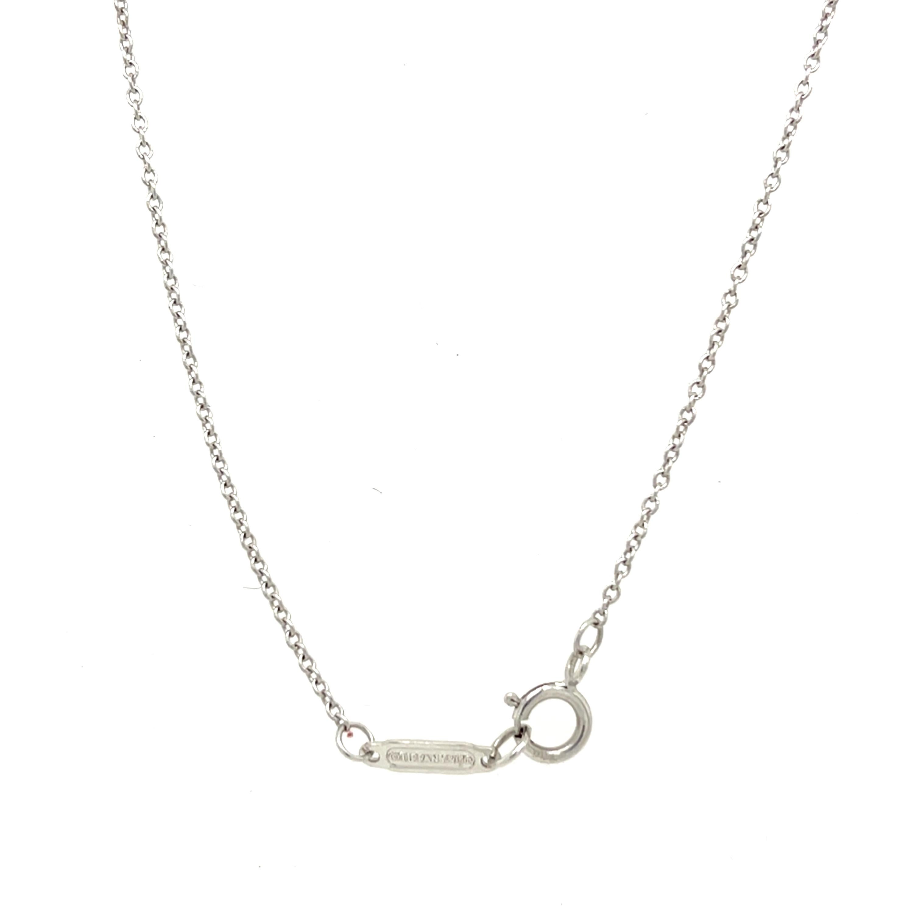 Una splendida opera di Tiffany & Co. Collana con ciondolo a forma di fiocco con diamanti, realizzata in oro bianco 18 carati e ornata da diamanti naturali con taglio a brillante. Questo squisito design incarna eleganza e femminilità, 
che lo rende