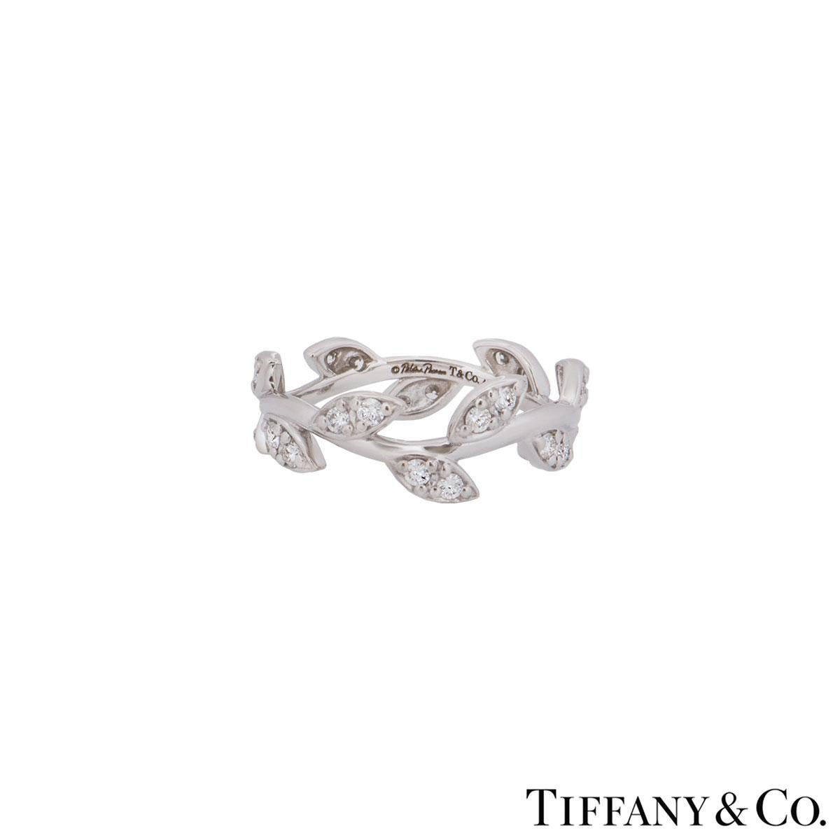 A stunning 18k white gold diamond leaf ring by Tiffany & Co. from the Paloma Picasso collection. The ring features a leaf design on a stem wrapped around pave set with round brilliant cut diamonds 0.28ct. The ring has a width of 4.00mm and is a UK