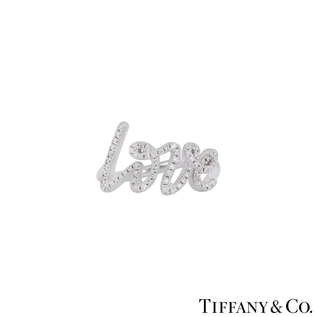 An 18k white gold diamond ring by Tiffany & Co. from the Paloma Picasso collection. The ring features the word love written in Paloma Picasso's own writing as the focal point pave set with round brilliant cut diamonds with a total weight of 0.20ct.
